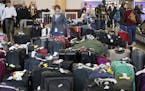 People look over luggage Monday, Dec. 18, 2017, at Hartsfield-Jackson International Airport in Atlanta. Power was restored at the airport after a mass