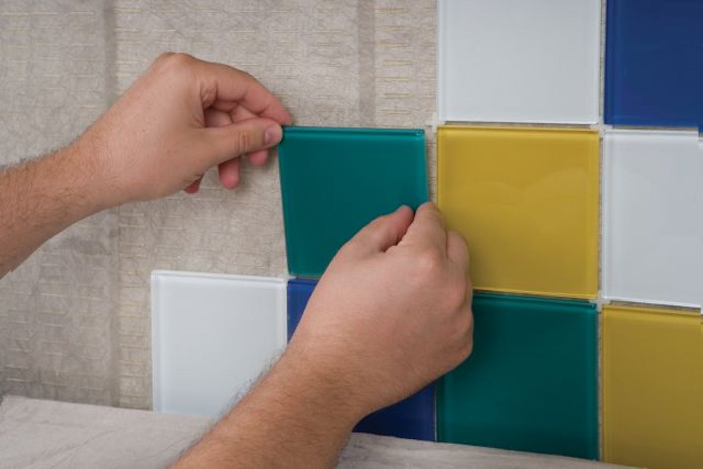 Simplemat offers an easier way to adhere tile to countertops and backsplashes. The double-sided adhesive mat eliminates the need for thin-set mortar or mastic adhesive. You just stick the Simplemat adhesive to the surface, apply the tile and grout as usual.