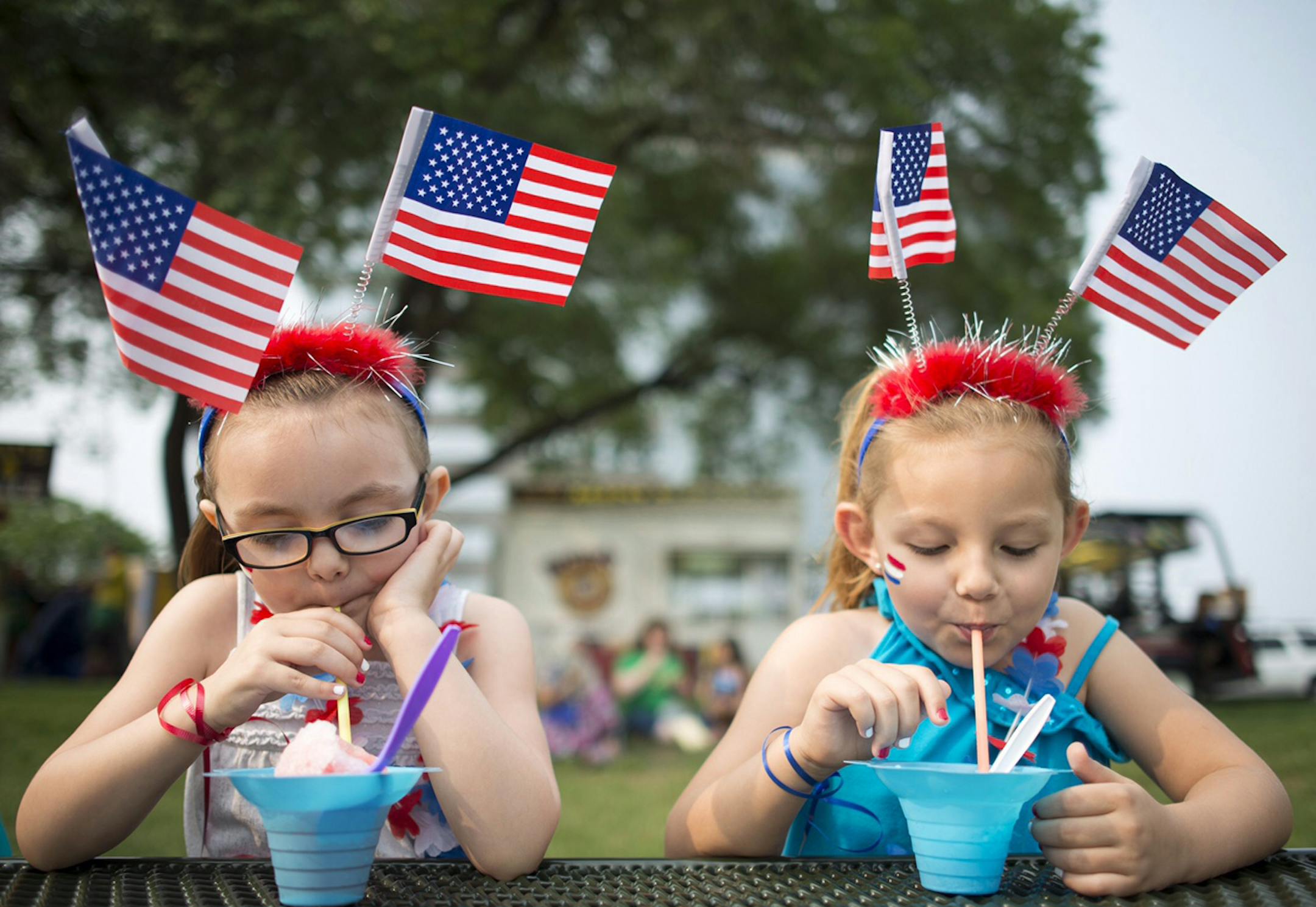 Sisters Alyksa Shaw, 5, and Ashlyn, 6, of Burnsville, enjoyed shaved ice while donning patriotic head gear at Summer Fete at Normandale Lake Park Friday afternoon. ] Aaron Lavinsky ï aaron.lavinsky@startribune.com Summer Fete was held at Normandale Lake Park on Friday, July 3, 2015 in Bloomington. ORG XMIT: MIN1507031857500906