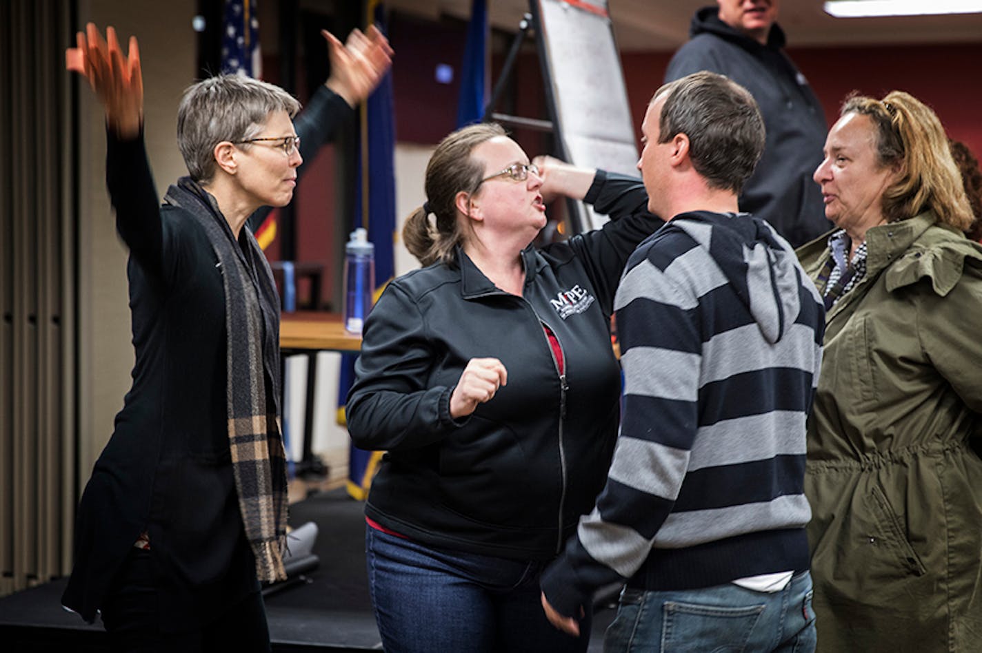 Trainer Debra Prokopf of Minnesota Association of Professional Employees, center in black, acts out a scenario as a counter protester during marshall training with Gena Berglund, left, co-captain of the marshalls and fellow trainer Steve Payne, in striped top, of the SEIU, as volunteer marshalls watch the scene to learn how to deal with potentially violent counter protesters.