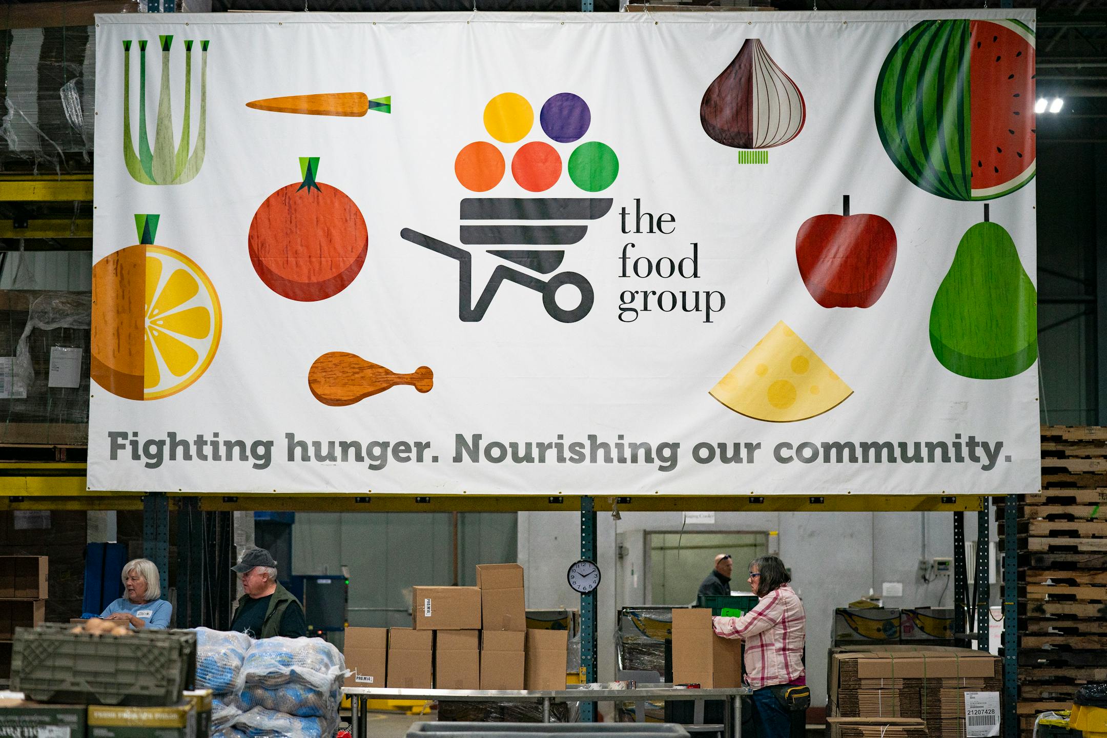 Volunteers with the Food Group help pack produce boxes.