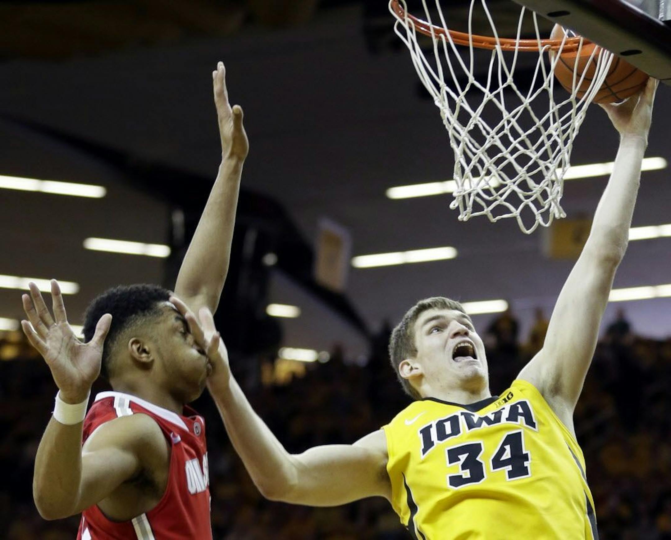 Iowa center Adam Woodbury, right, drives to the basket past Ohio State guard D'Angelo Russell during the second half of an NCAA college basketball game, Saturday, Jan. 17, 2015, in Iowa City, Iowa. Iowa won 76-67.