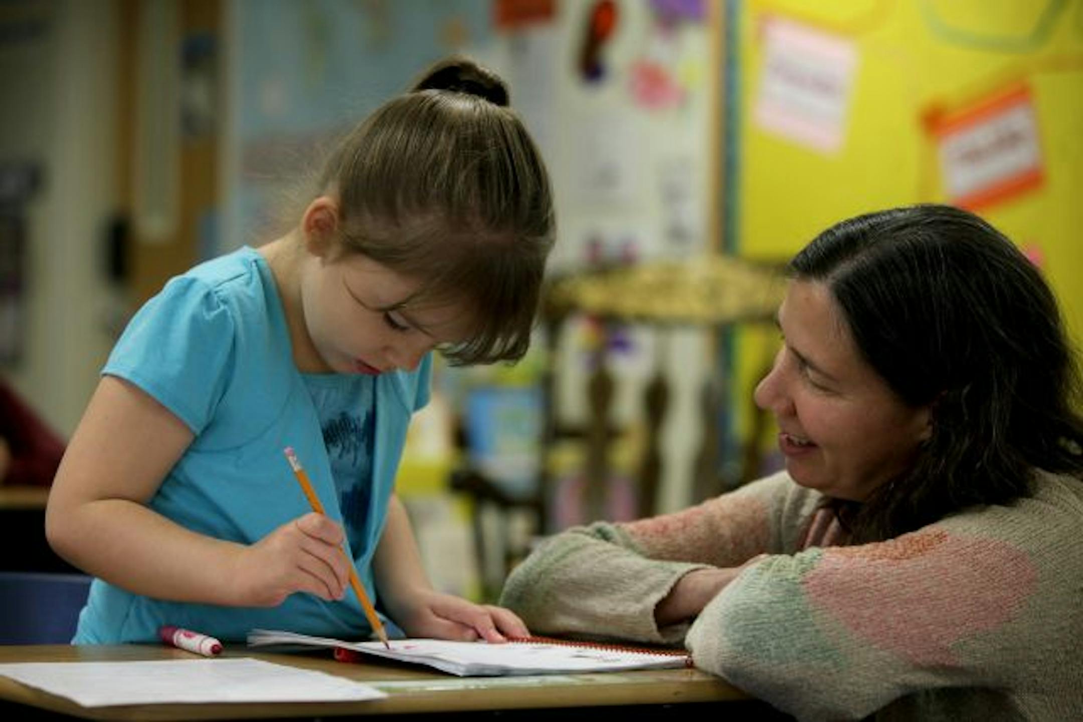 Teacher's Aid Libby Hoops guided Keira Edling, 5, of California, through a writing assignment.