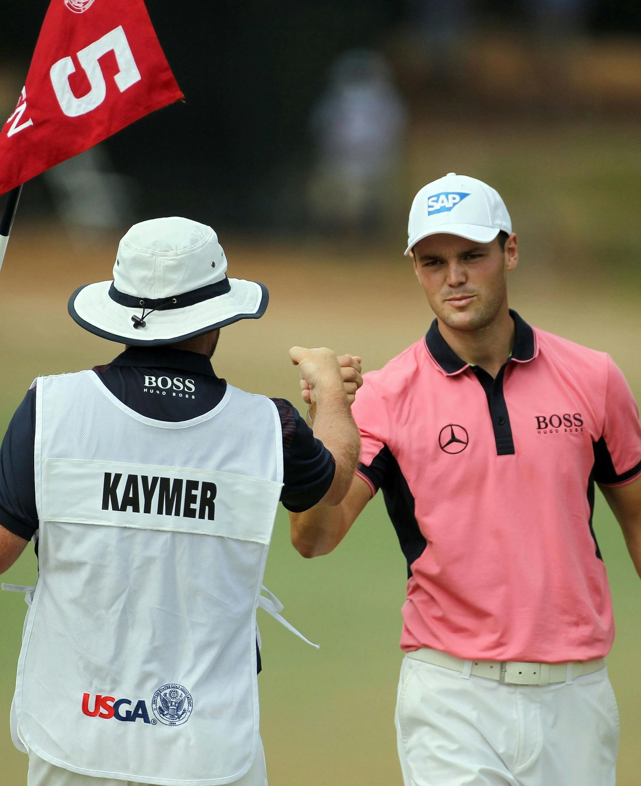 Golfer Martin Kaymer of Dusseldorf, Germany, right, fist bumps his caddy, Craig Connolly, after an eagle on the fifth hole during the third round of the 2014 U.S. Open at Pinehurst No. 2 in Pinehurst, N.C., Saturday, June 14, 2014. (Robert Willett/Raleigh News & Observer/MCT)