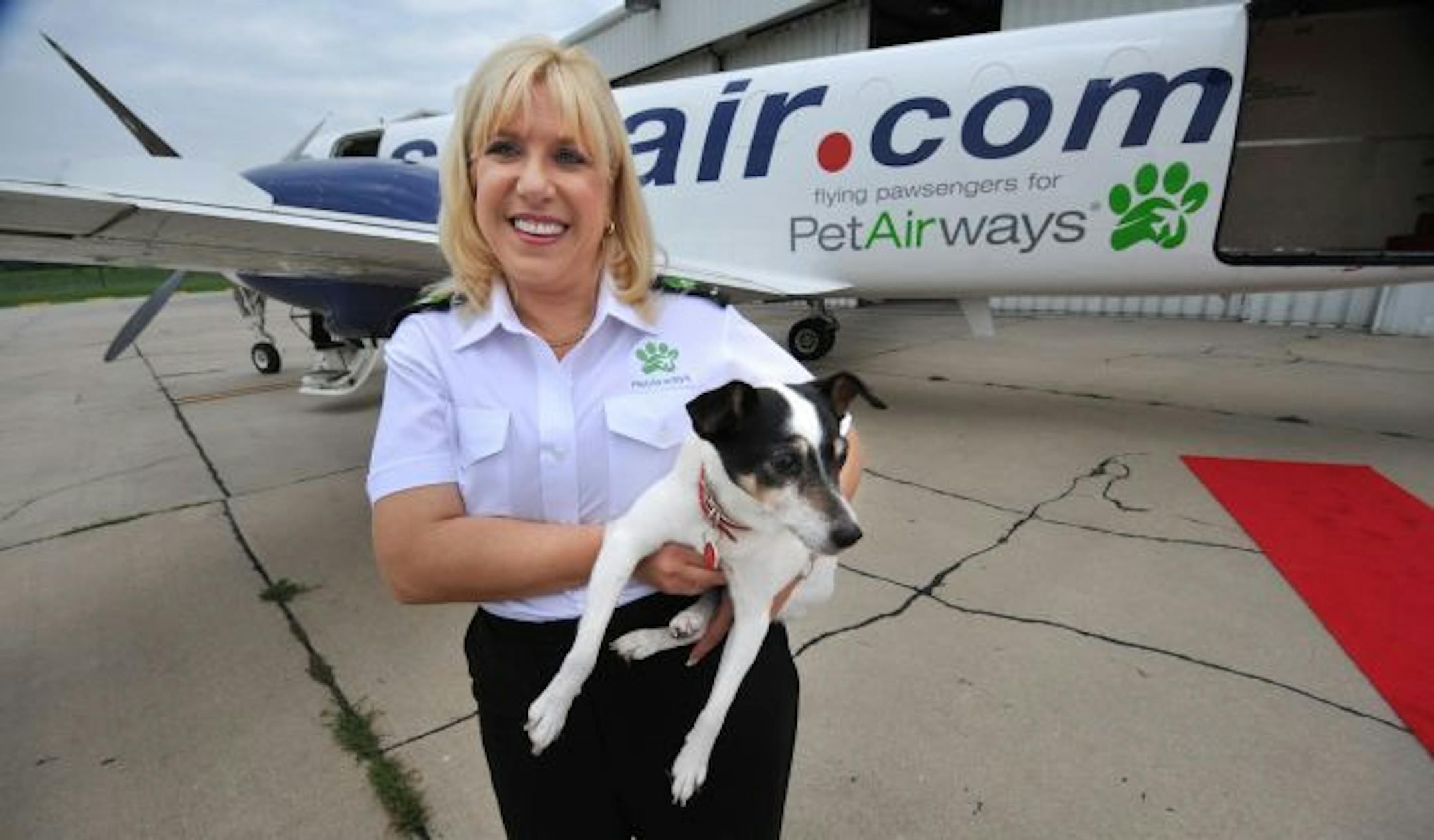 In this photo made Thursday, July 9, 2009, Pet Airways Co-founder Alysa Binder holds her dog, Zoe, in Omaha, Neb. On the first-ever all-pet airline started by Binder and her husband, Dan Wiesel, dogs and cats will fly in the main cabin of a Suburban Air Freight plane, retooled and lined with carriers in place of seats.