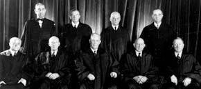 Members of the U.S. Supreme Court are seen in a 1953 photo before they issued the first school integration order in 1954. From Left, seated Associated