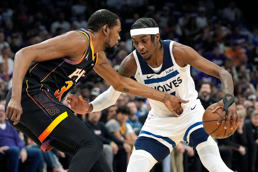 Minnesota Timberwolves forward Jaden McDaniels, right, tries to get past Phoenix Suns forward Kevin Durant during the first half of Game 4 of an NBA basketball first-round playoff series, Sunday, April 28, 2024, in Phoenix. (AP Photo/Ross D. Franklin)