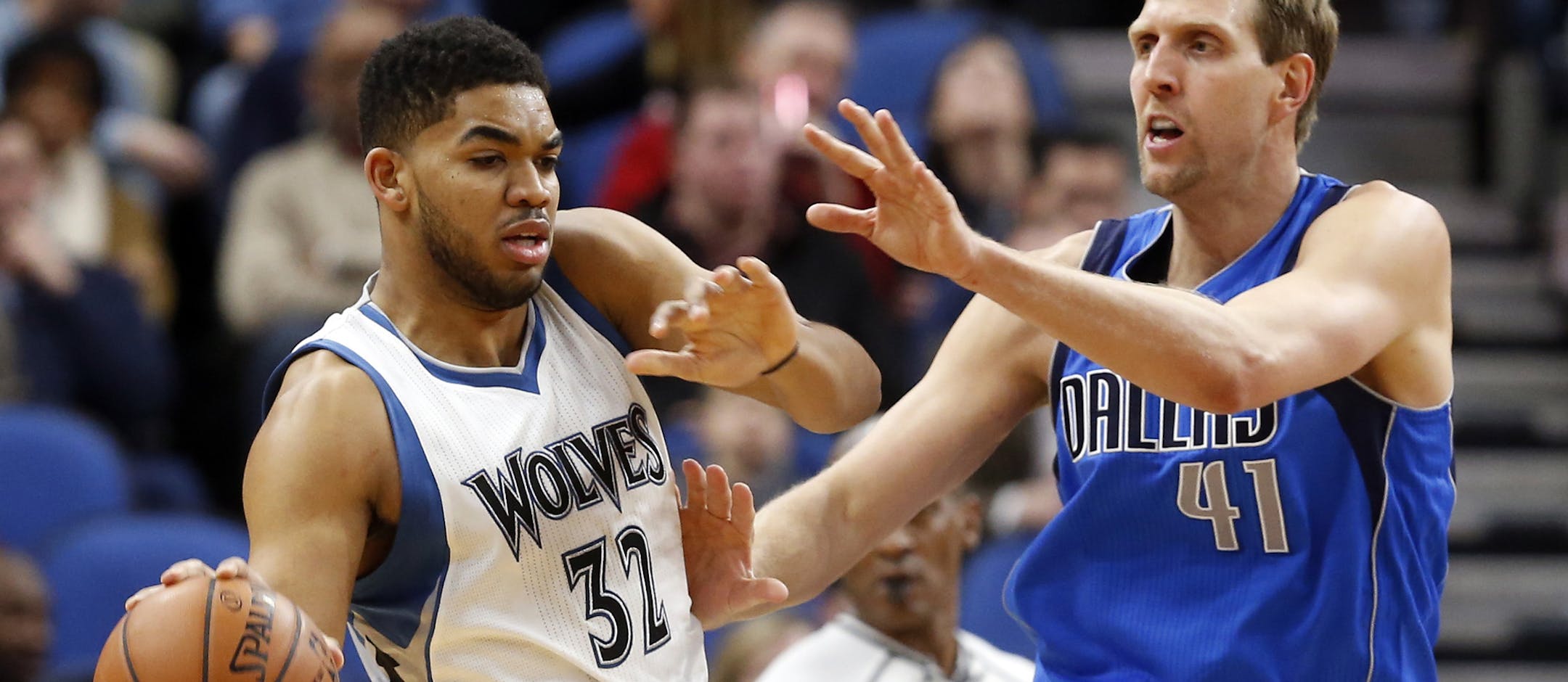 Minnesota Timberwolves' Karl-Anthony Towns, left, keeps the ball away from Dallas Mavericks' Dirk Nowitzki of Germany, during the second half of an NBA basketball game Friday, Feb. 24, 2017, in Minneapolis. (AP Photo/Jim Mone)