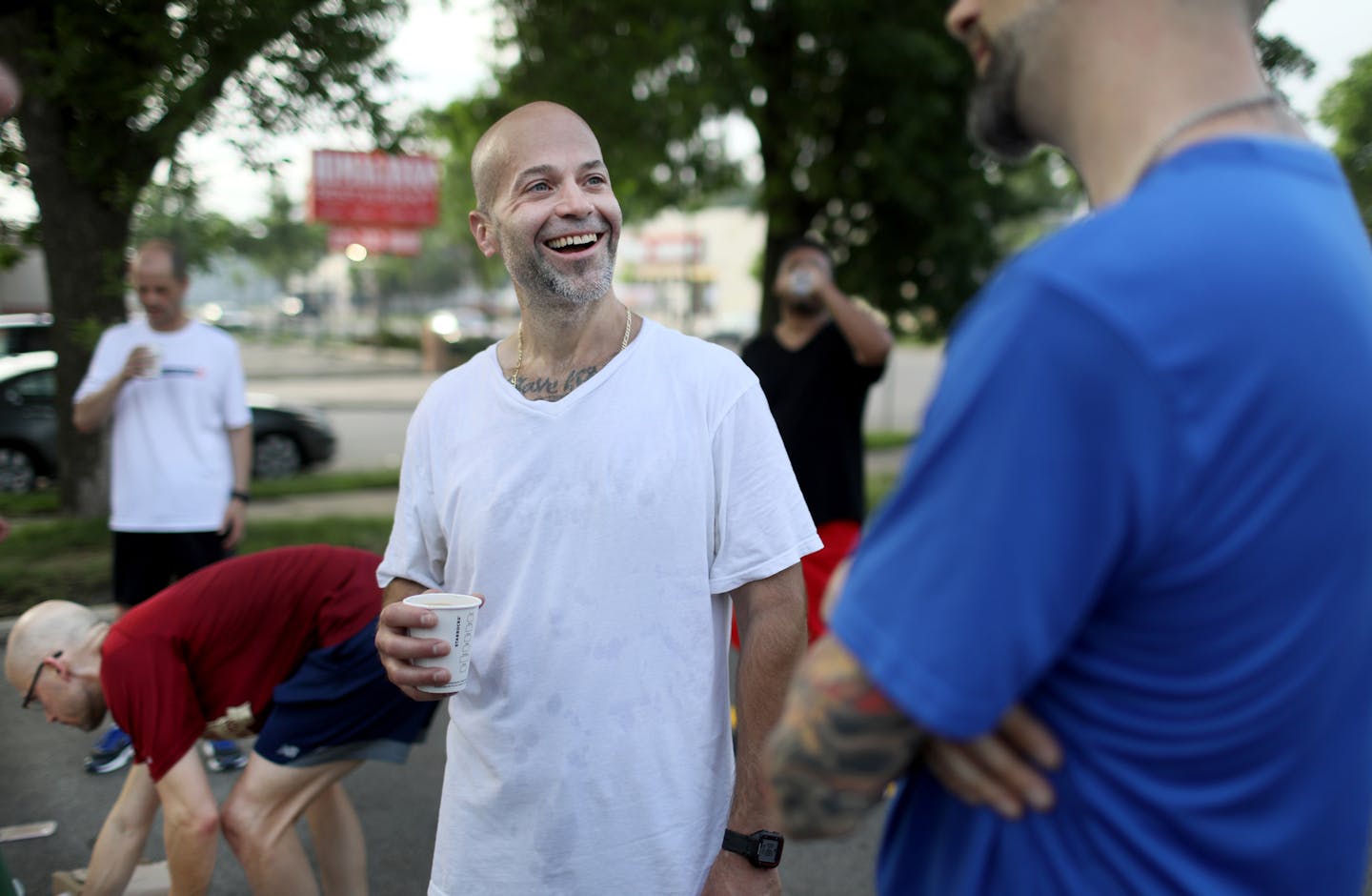 Shane Peterson, center, who was recently released from prison after a 17-year stint, chats with group members after a group work out on the city's south side Thursday, May 31, 2018, in Minneapolis, MN.] DAVID JOLES ï david.joles@startribune.com A local program, "Mile in My Shoes," helps people who are homeless and ex-prisoners reintegrate back into mainstream society through running and form relationships through a community of long-distance runners. They train several times a week in teams on a