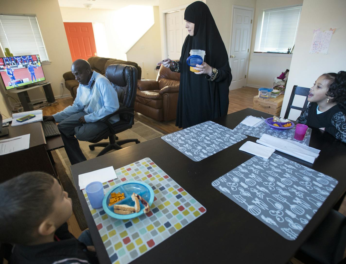 Sarah Olson grabbed lunch for her two 7-year old children, Jamal and Sofia, as their father, Mohamed Abdi, sat down at the computer Saturday afternoon. ] (AARON LAVINSKY/STAR TRIBUNE) aaron.lavinsky@startribune.com A newly released study by the Wilder Foundation of families that have moved into Habitat for Humanity homes reads like a litany of good news. Habitat families report a host of positive impacts from their move. More than half say their kids are doing better in school; more than 40 perc