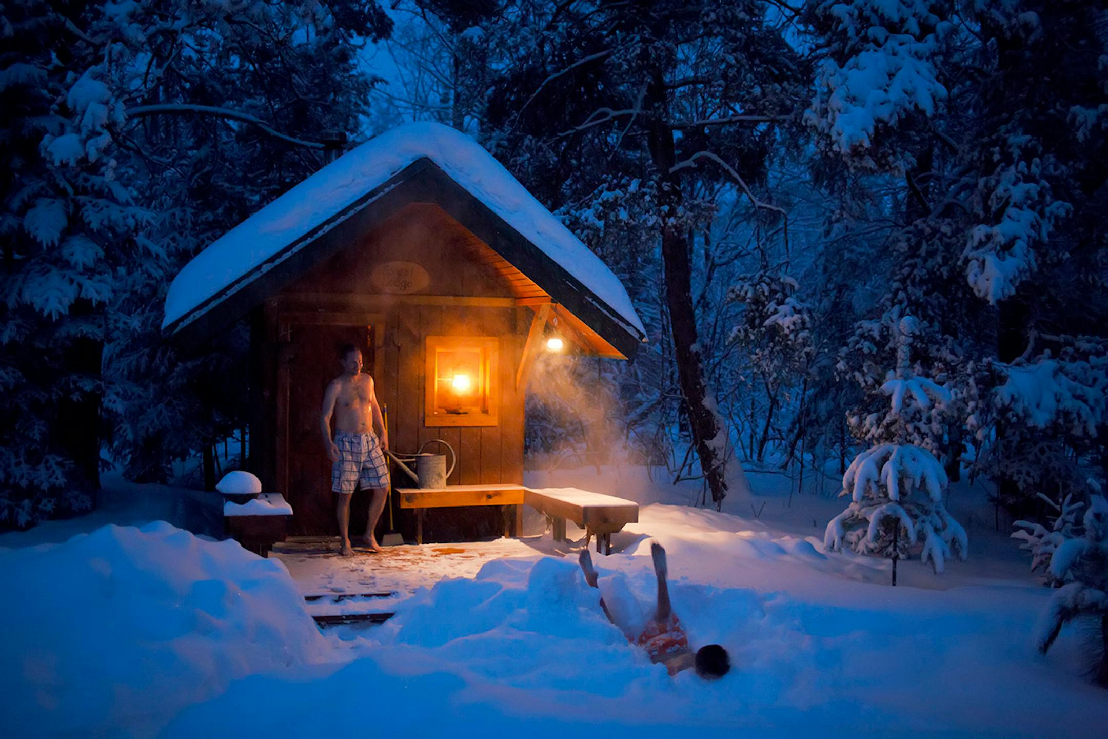 Leaving a trail of steam behind, Brendan Peterson dives head first into fresh powder after soaking his body in 190 degree heat of a traditional wood fired sauna near Cotton. Brendan's father Kevin wait's his turn. ] Minnesota -State of Wonders, Arrowhead in Winter BRIAN PETERSON • brian.peterson@startribune.com Cotton, MN 2/14/2014