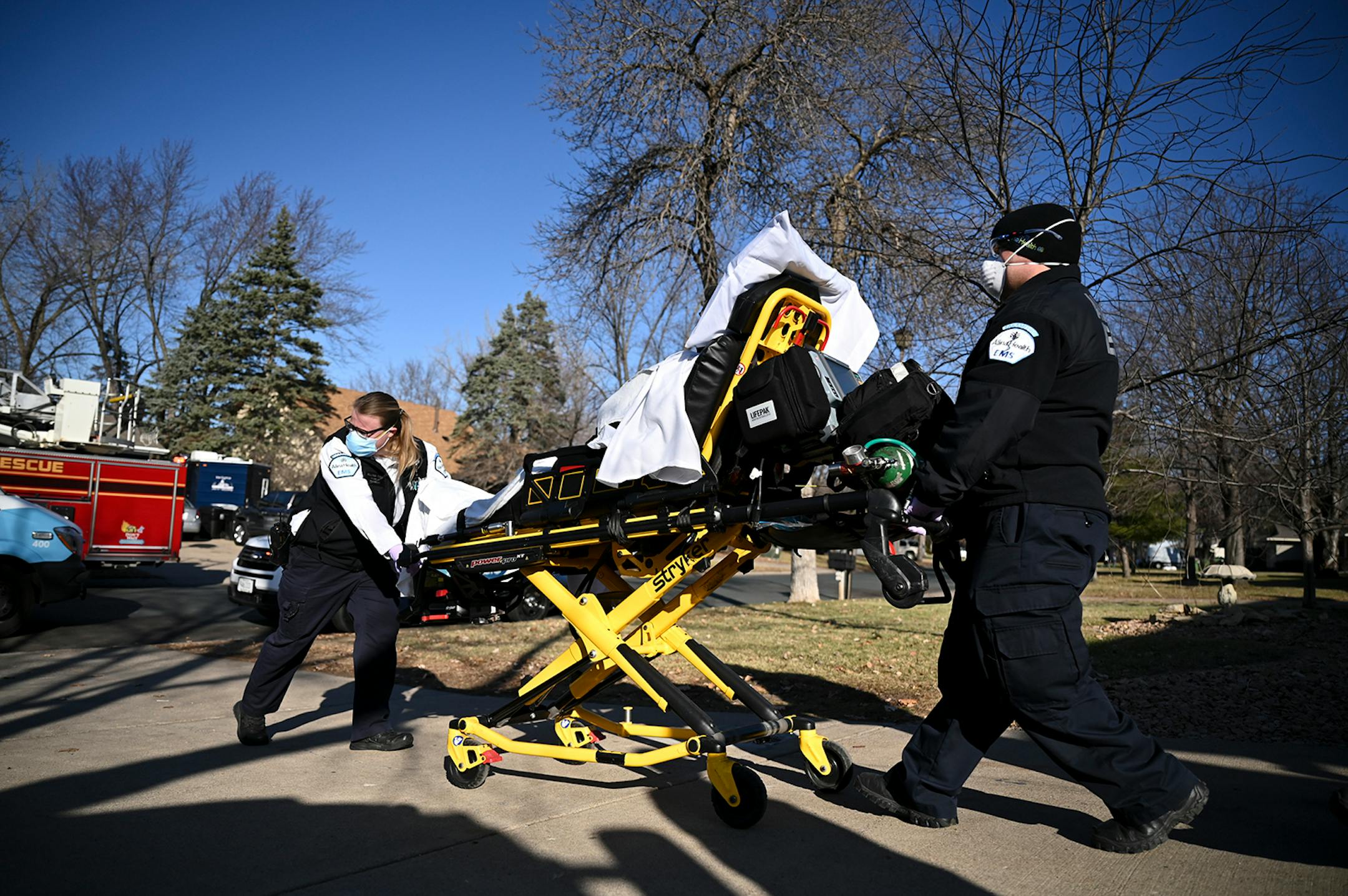 Allina Health paramedics Kelsey Cook and Dan Lennartson pushed a patient on a gurney out to their ambulance Wednesday afternoon while responding to a call in Coon Rapids. The patient was suspected to be having a COVID-19 related medical emergency. ] AARON LAVINSKY • aaron.lavinsky@startribune.com Emergency medical workers and physician Andrew Stevens responded to possible COVID-19 related calls on Wednesday, Dec. 2, 2020 in the north Twin Cities metro.