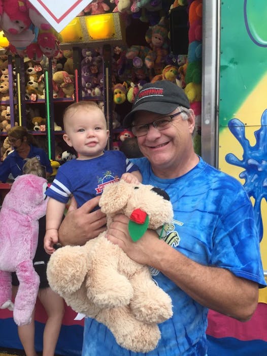 Steve Chamberlain won a stuffed dog at the Midway for his grandson, 9-month-old Teddy Larson, on his first fair visit.