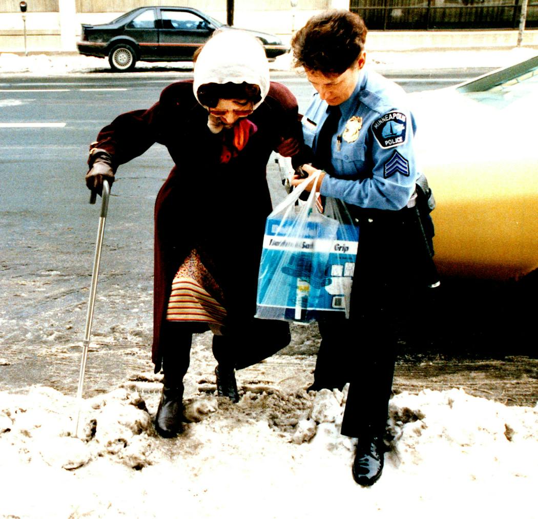 Minneapolis police Sgt. Sharon Lubinski helps a woman over an icy curb in 1993. That week, she and other gay and lesbian police officers asked Chief John Laux to establish a task force to address their concerns within the department and to study and improve the policing of and for the Minneapolis gay and lesbian community.  
