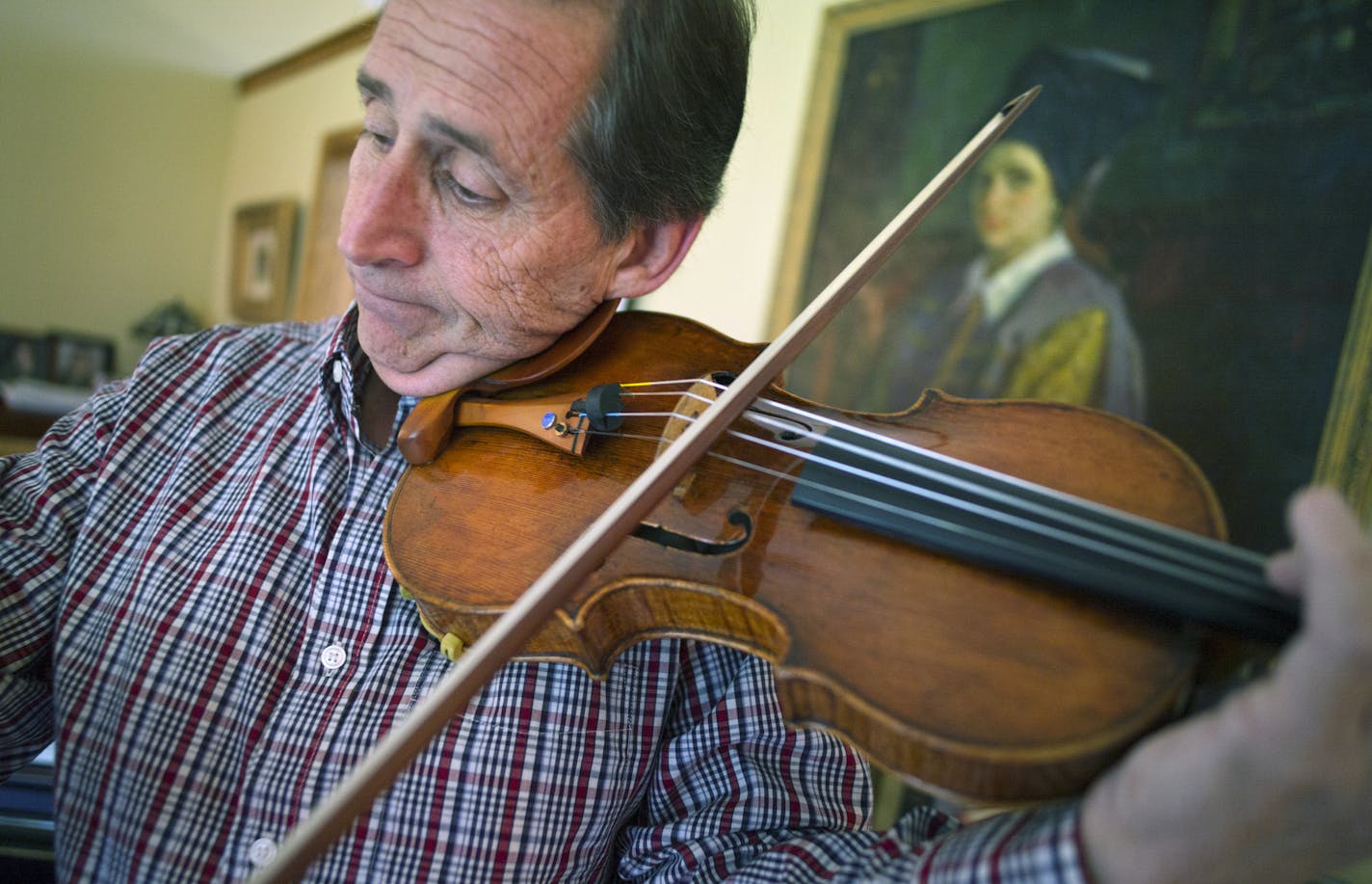 On October 5, Roger Frisch from Plymouth shows off his tremor-free control thanks to a Medtronic brain stimulation implant device. He will join 24 other long-distance runners from around the world as one of the 2014 Medtronic Global Heroes. As a Concertmaster for the Minnesota Orchestra, Roger relies on his steady hand and his healthy runner body to play the violin to his fullest potential .]Richard Tsong-Taatarii/rtsong- taatarii@startribune.com