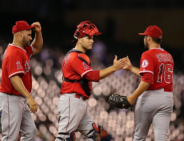 Los Angeles catcher Chris Iannetta congratulated closer Huston Street (16) after the final out of the ninth inning Thursday night at Target Field. Ang
