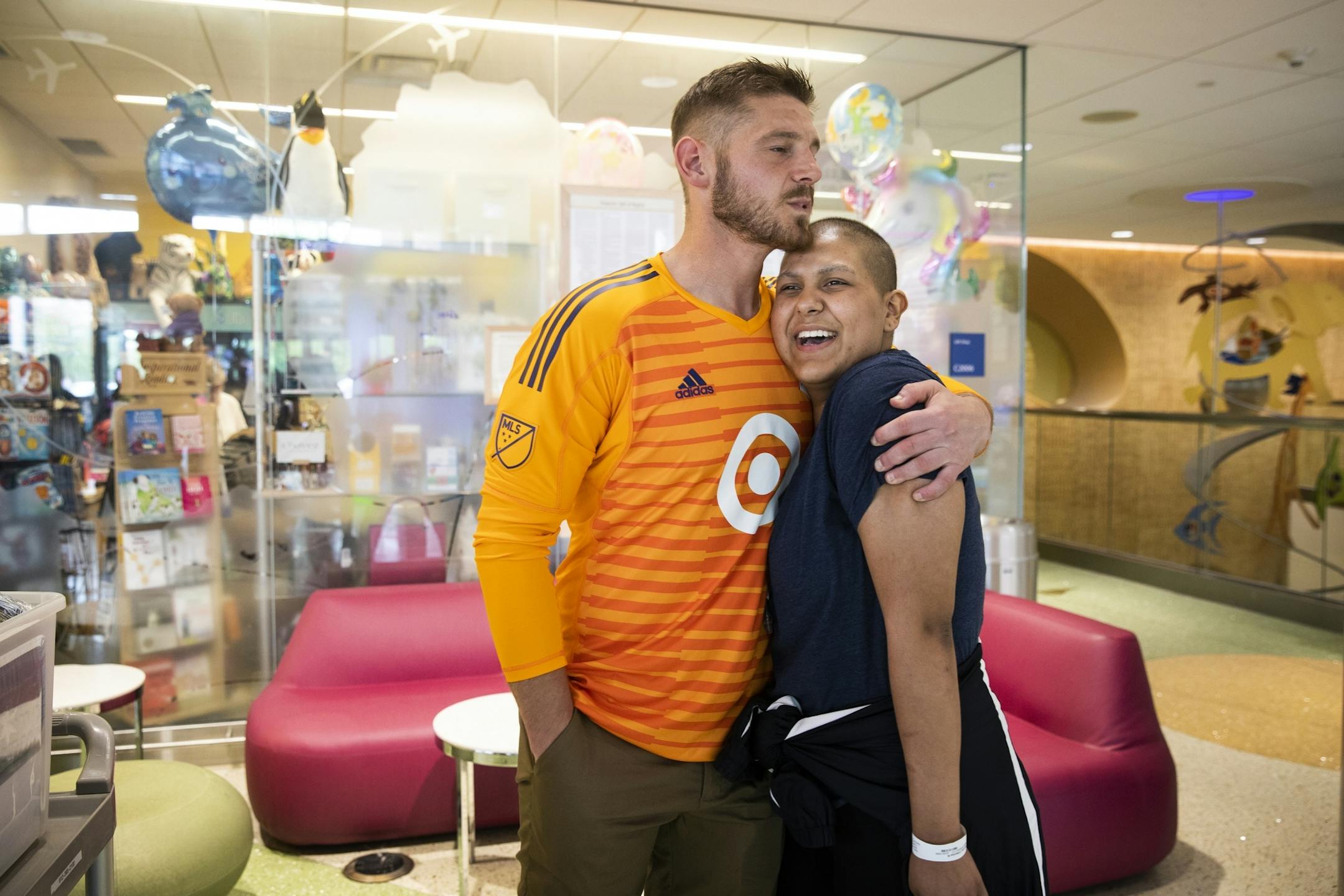Catarina Gomez, 18, a brain cancer patient, gets a hug from Minnesota United goalkeeper Matt Lampson during his visit to the hospital.
