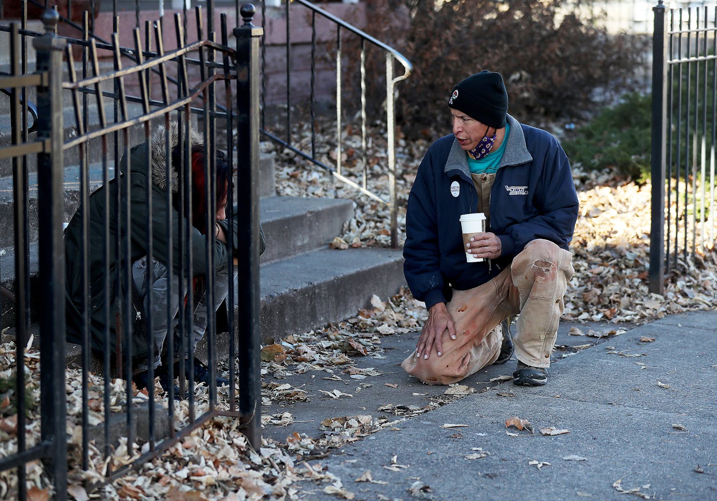 Allen Touche, 48, kneels down to comfort a woman who had been slumped over, her head in her lap, as Touche passed on his weekly Saturday journey to help feed homeless Natives and others in Minneapolis. Touche, who told the woman he has battled hard times and later brought her a plate of food, this past summer slept in a tent on a site in Minneapolis know as the Wall of Forgetten Natives. While still homeless, Touche succeeded in getting a union job working construction on an apartment complex ac