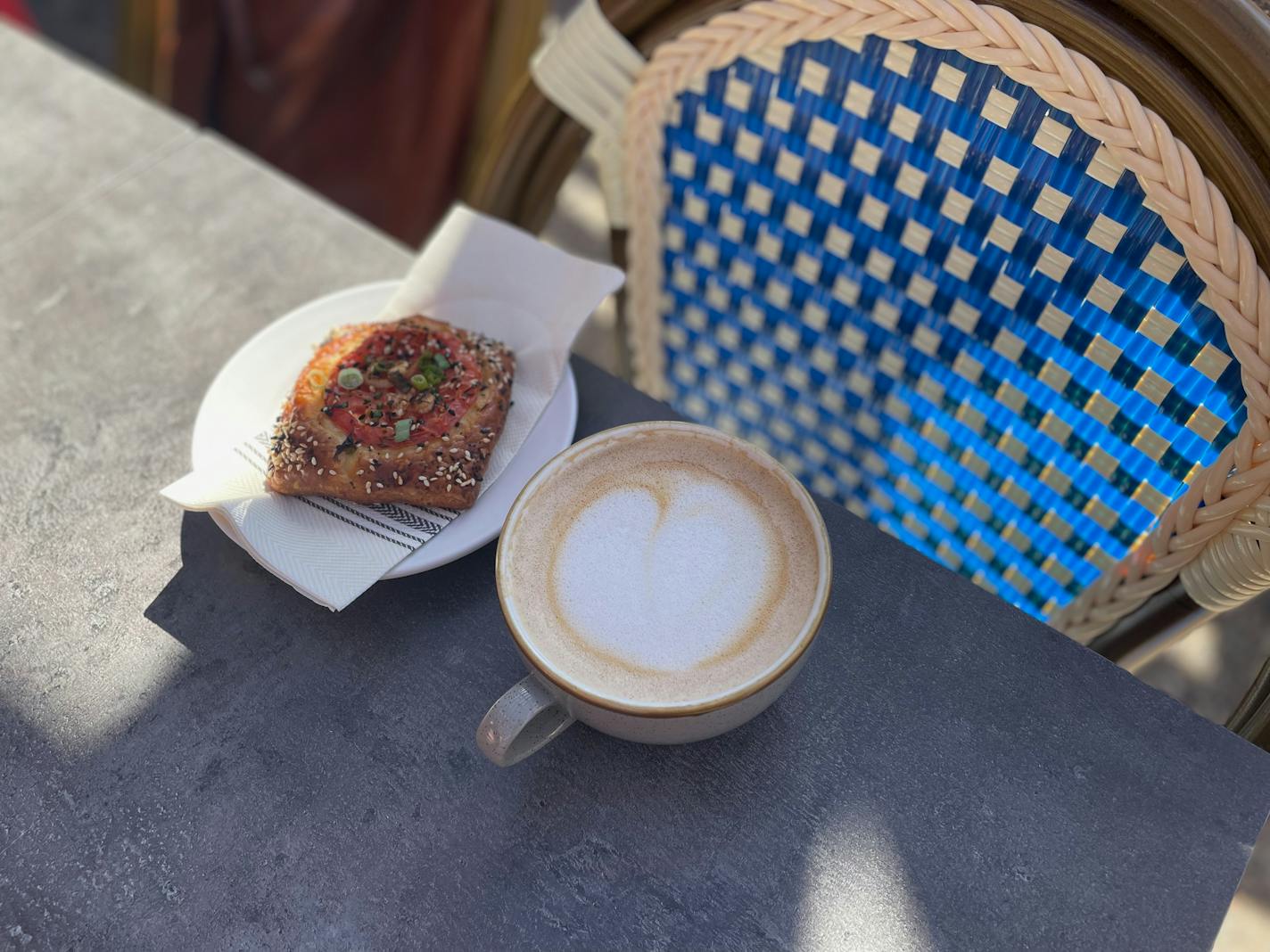 A tomato danish and latte with heart froth art.