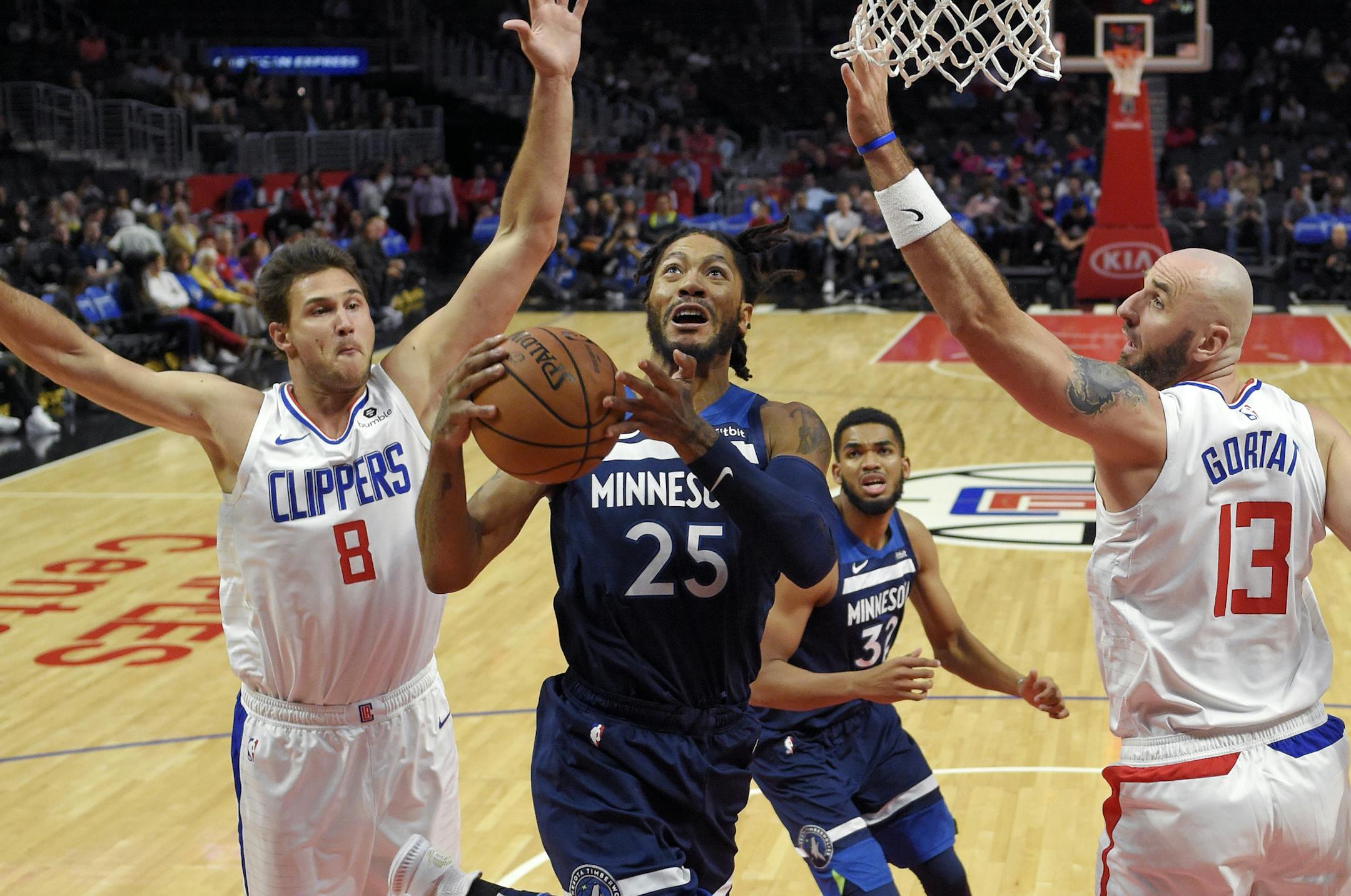 Minnesota Timberwolves guard Derrick Rose, center, shoots as Los Angeles Clippers forward Danilo Gallinari, left, of Italy, and center Marcin Gortat, of Poland, defend during the first half of an NBA preseason basketball game Wednesday, Oct. 3, 2018, in Los Angeles. (AP Photo/Mark J. Terrill)