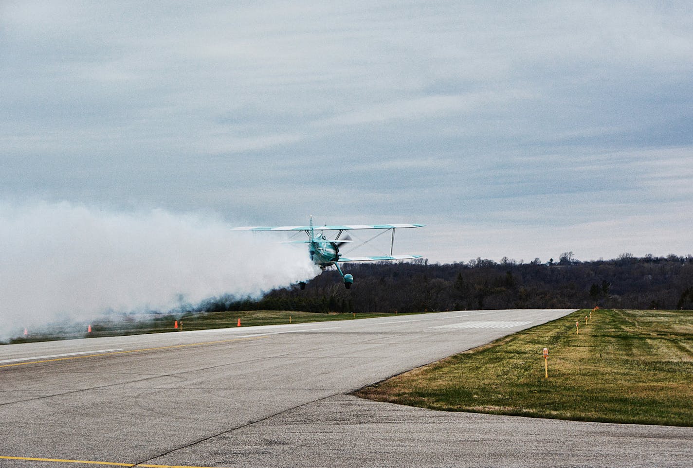 Le Sueur, Minnesota USA - May 3, 2014: A bi-plane with fogger soars over a runway at a small rural airport in South Central Minnesota