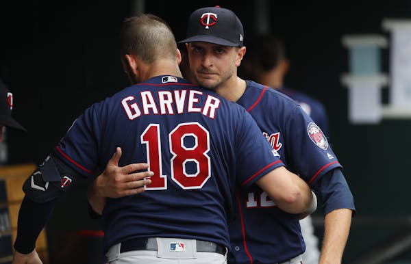 Minnesota Twins pitcher Jake Odorizzi, right, hugs catcher Mitch Garver (18) in the dugout in the sixth inning of a baseball game against the Detroit 