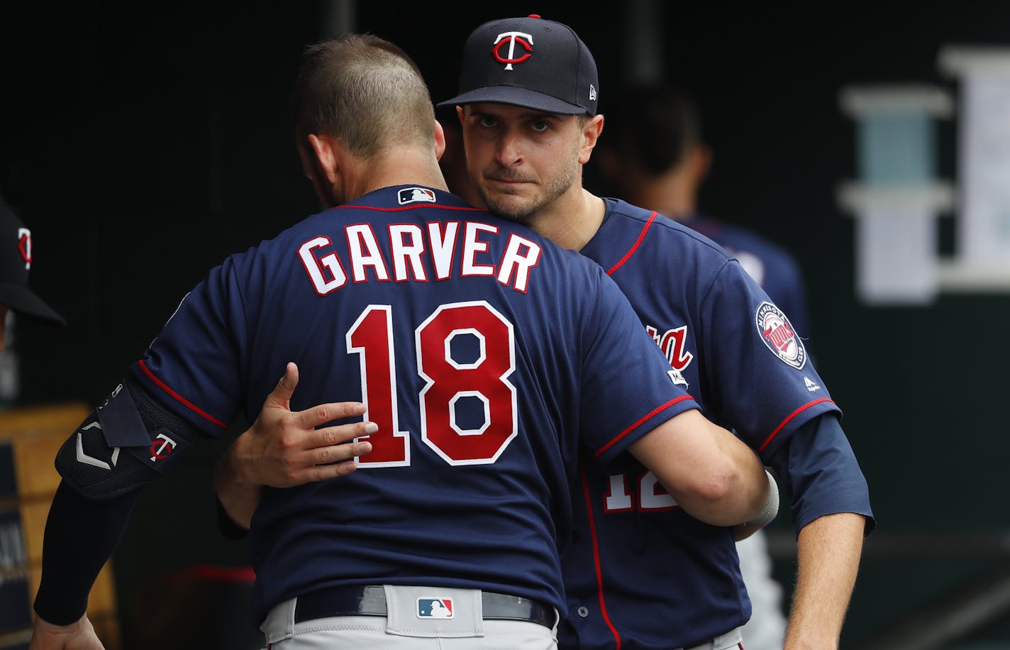 Minnesota Twins pitcher Jake Odorizzi, right, hugs catcher Mitch Garver (18) in the dugout in the sixth inning of a baseball game against the Detroit Tigers in Detroit, Sunday, June 9, 2019. (AP Photo/Paul Sancya)