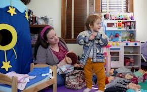 Linnae Nelson-Seys plays with her daughter, Rosemary, 2, at their home in Minneapolis while waiting for the bus to bring her other daughter home from