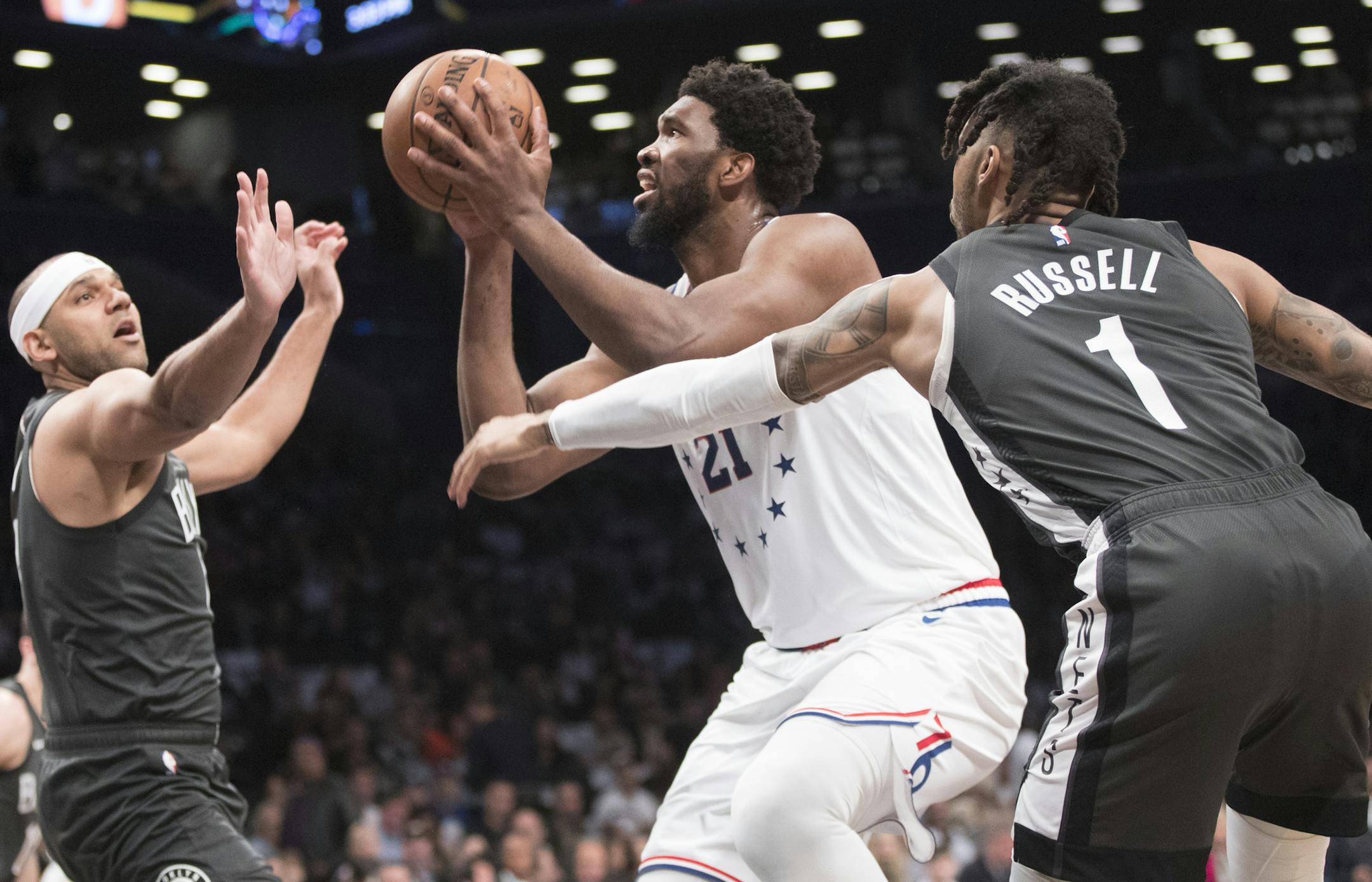 Philadelphia 76ers center Joel Embiid (21) goes to the basket against Brooklyn Nets guard D'Angelo Russell (1)and forward Jared Dudley during the first half of Game 4 of a first-round NBA basketball playoff series, Saturday, April 20, 2019, in New York. (AP Photo/Mary Altaffer)