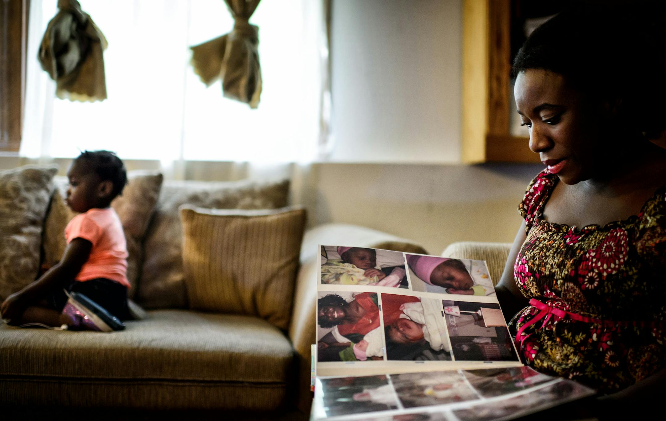 Decontee Sawyer looked through a photo album with photos of her late husband and her three children growing up. She was at her home in Coon Rapids with her daughter Bella. She lost her husband Patrick to Ebola last year. ] GLEN STUBBE * gstubbe@startribune.com Friday, July 24, 2015 Decontee Sawyer at her home in Coon Rapids with her daughter Bella. She lost her husband Patrick to Ebola last year.