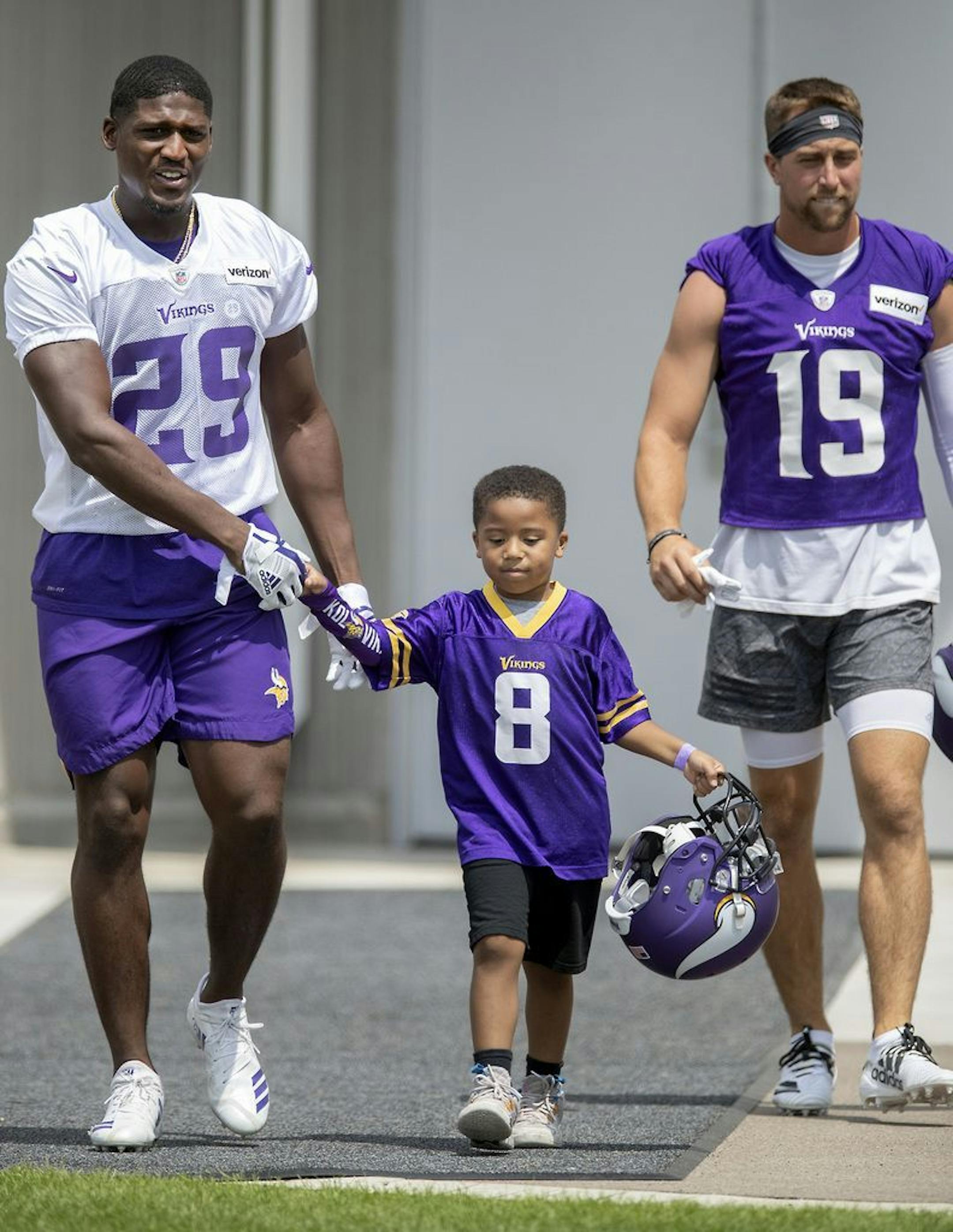 Minnesota Vikings Xavier Rhodes got help with his helmet from fan Braydan Lankford, 4, who greeted players as they made their way on the field for the first full day of practice at Vikings training camp at the TCO Performance Center, Friday, July 26, 2019 in Eagan, MN.
