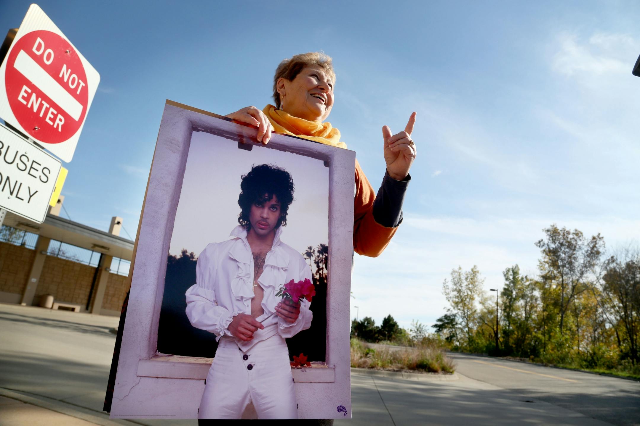 Phyllis Jackson of Red Wing holds her Prince posters while talking to a photographer after being dropped off by bus at the Southwest Transit Center following the Paisley Park tour Thursday, Oct. 6, 2016, in Chanhassen, MN.