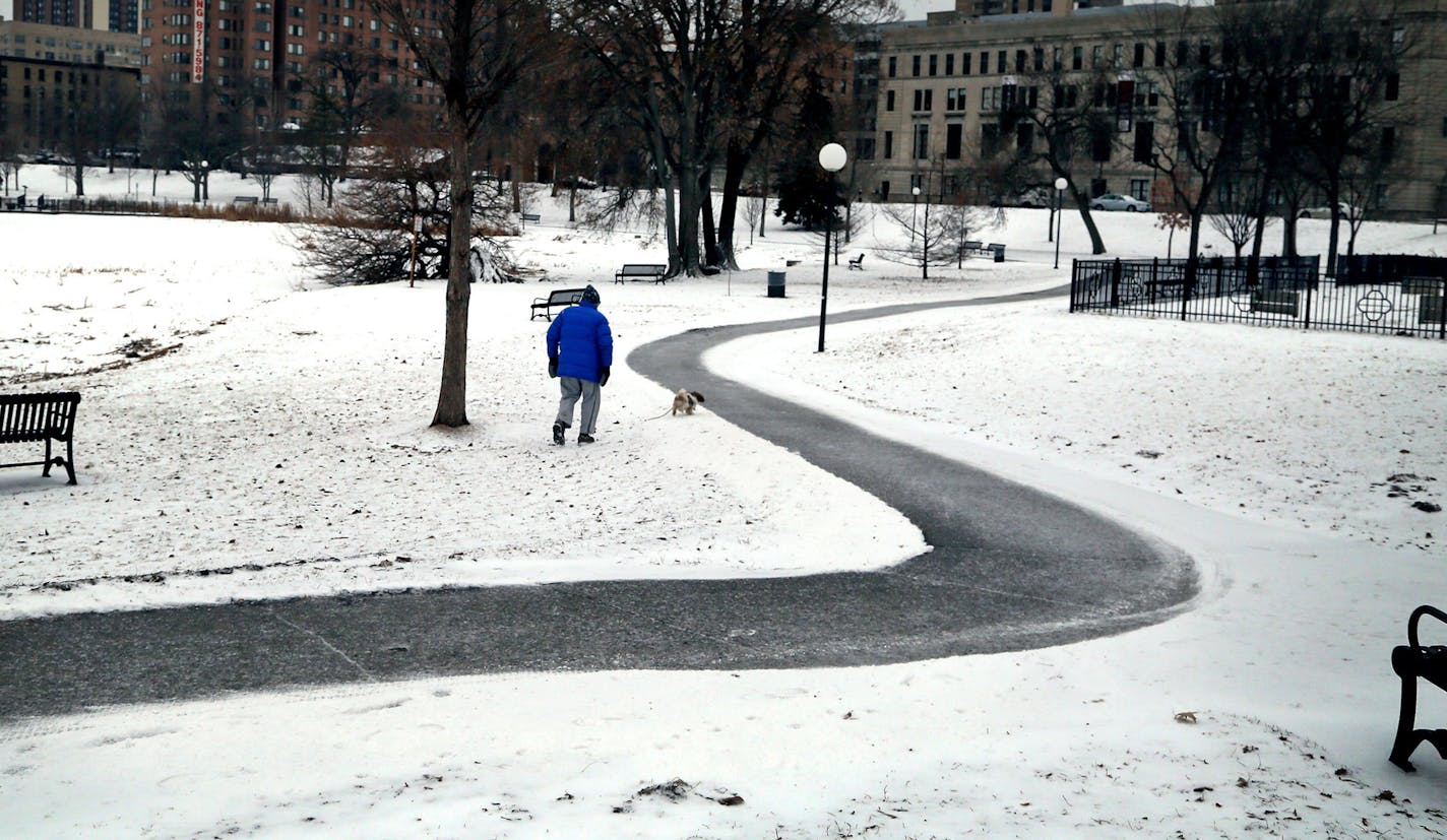 A man and his dog make their way along an ice-covered trail in Loring Park Tuesday, Feb. 10, 2015 in Minneapolis, MN.](DAVID JOLES/STARTRIBUNE)djoles@startribune.com Snow, freezing rain and spinouts mar morning commute and snow through the day could mean a bad evening commute, too. ORG XMIT: MIN1502101436294569