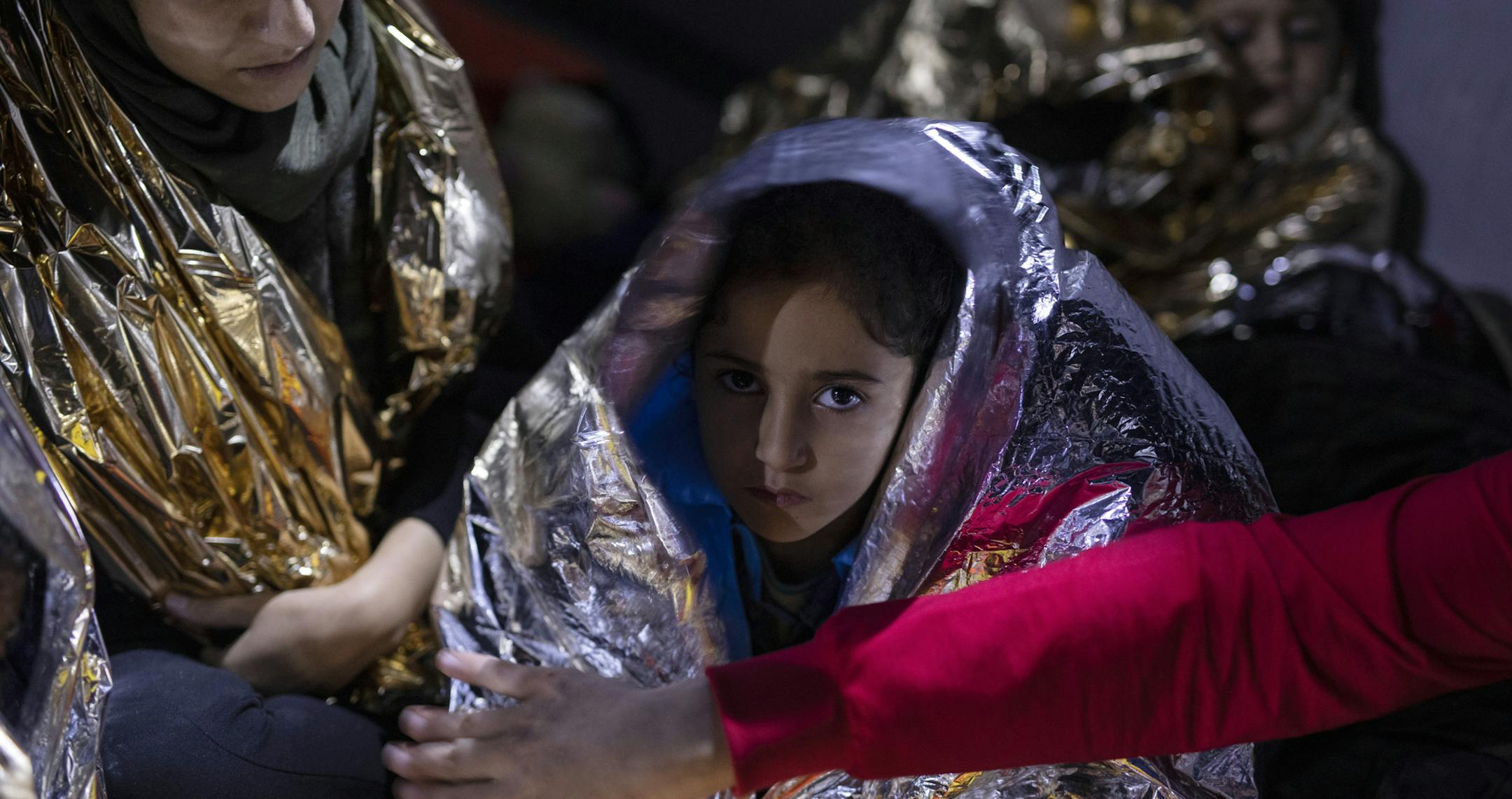 A Iraqi girl looks on as she is covered with a thermal blanket after she and other migrants and refugees were rescued by the Greek coast guard, early Thursday, Sept. 26, 2019, near the Greek island from Samos. 23 migrants and refugees from Syria, Iraq, Palestine and Iran who tried to cross the Aegean Sea from Turkey to the Greek island of Samos on a plastic boat, were rescued by the Greek coast Guard. (AP Photo/Petros Giannakouris)