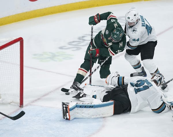 Minnesota Wild left wing Zach Parise (11) tried to get his stick on the puck in the third period while San Jose Sharks defenseman Marc-Edouard Vlasic 