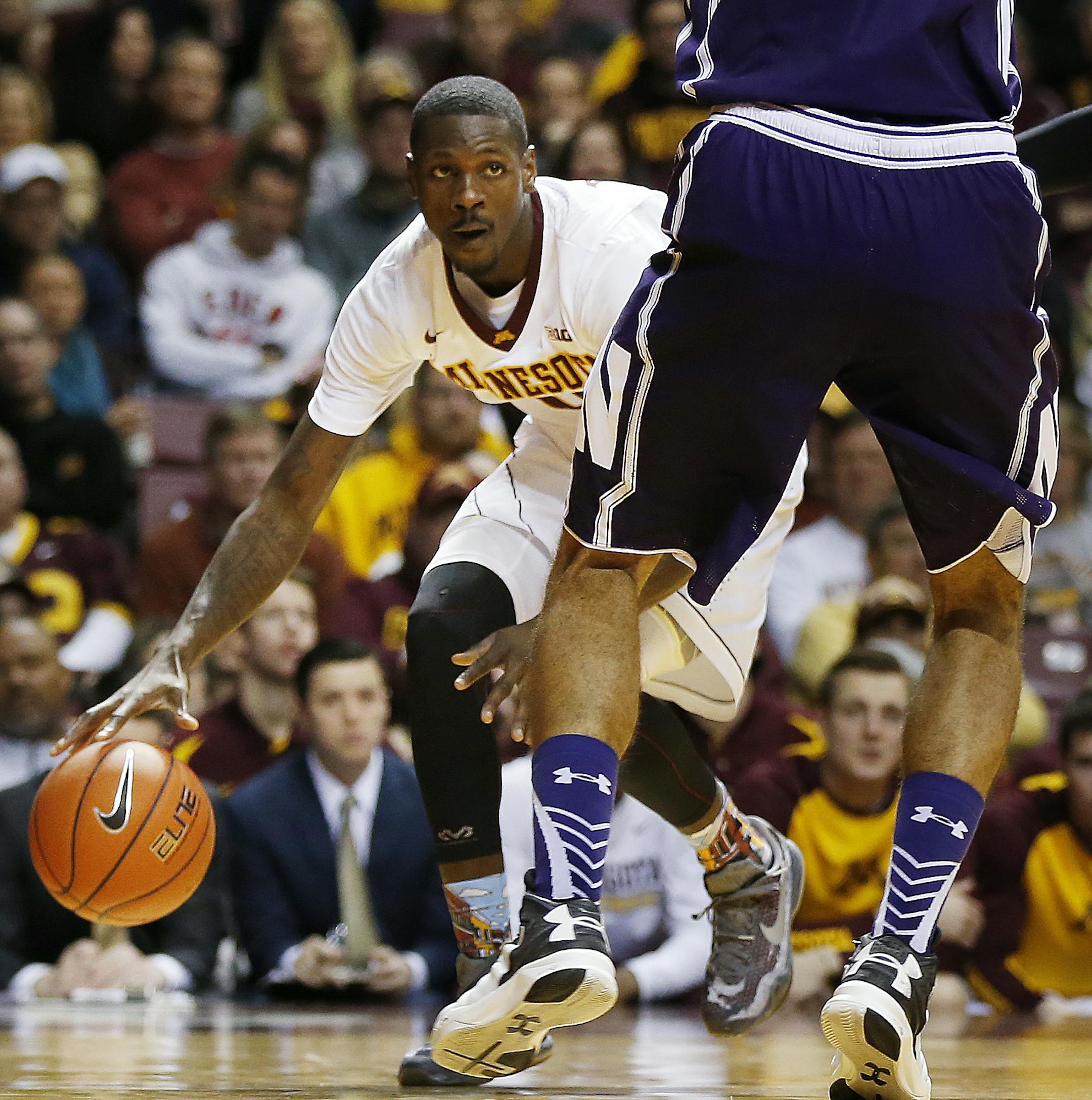 Minnesota guard Carlos Morris (11) protects the ball against the defense of Northwestern center Joey van Zegeren (1) in the second half of an NCAA college basketball game, Saturday, Jan. 9, 2016, at Williams Arena in Minneapolis. (AP Photo/Stacy Bengs)