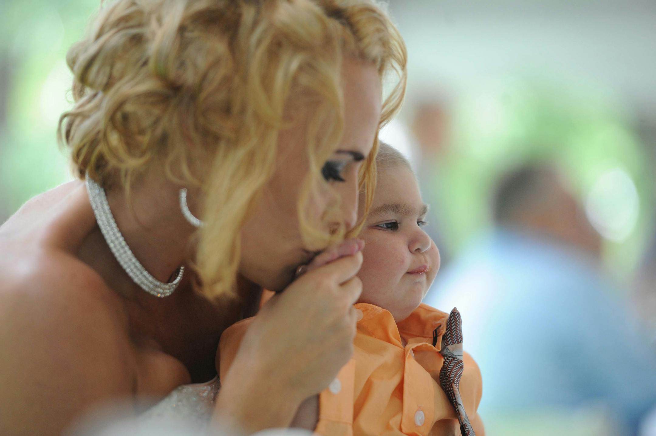 Newlywed Christine Stevenson kisses the hand of her son, Logan Stevenson, 2, after marrying Sean Stevenson in a wedding ceremony on Saturday, Aug. 3, 2013 in Jeannette, Pa. The Stevensons abandoned an original wedding date of July 2014 after learning from doctors late last month that their son had two to three weeks to live.