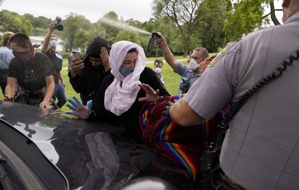 A Minneapolis park police officer sprayed mace after protesters blocked the path of a cruiser attempting to leave the area in Powderhorn Park on Frida