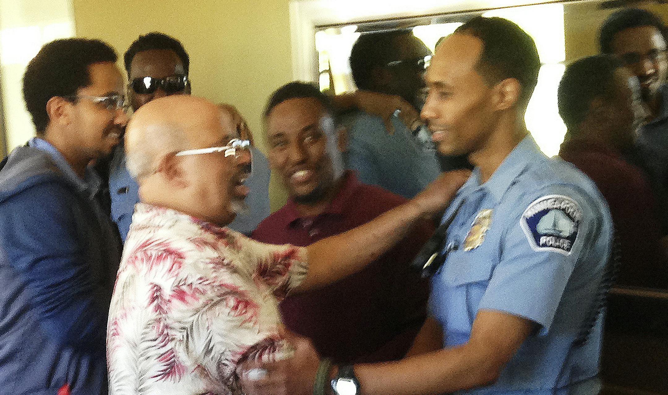 In this May 2016 photo provided by the City of Minneapolis, police Officer Mohamed Noor, right, is greeted by a well-wisher at a community event welcoming him to the Minneapolis police force. Noor has been identified as the officer who fatally shot Justine Damond, of Sydney, Australia, late Saturday, July 15, 2017.
