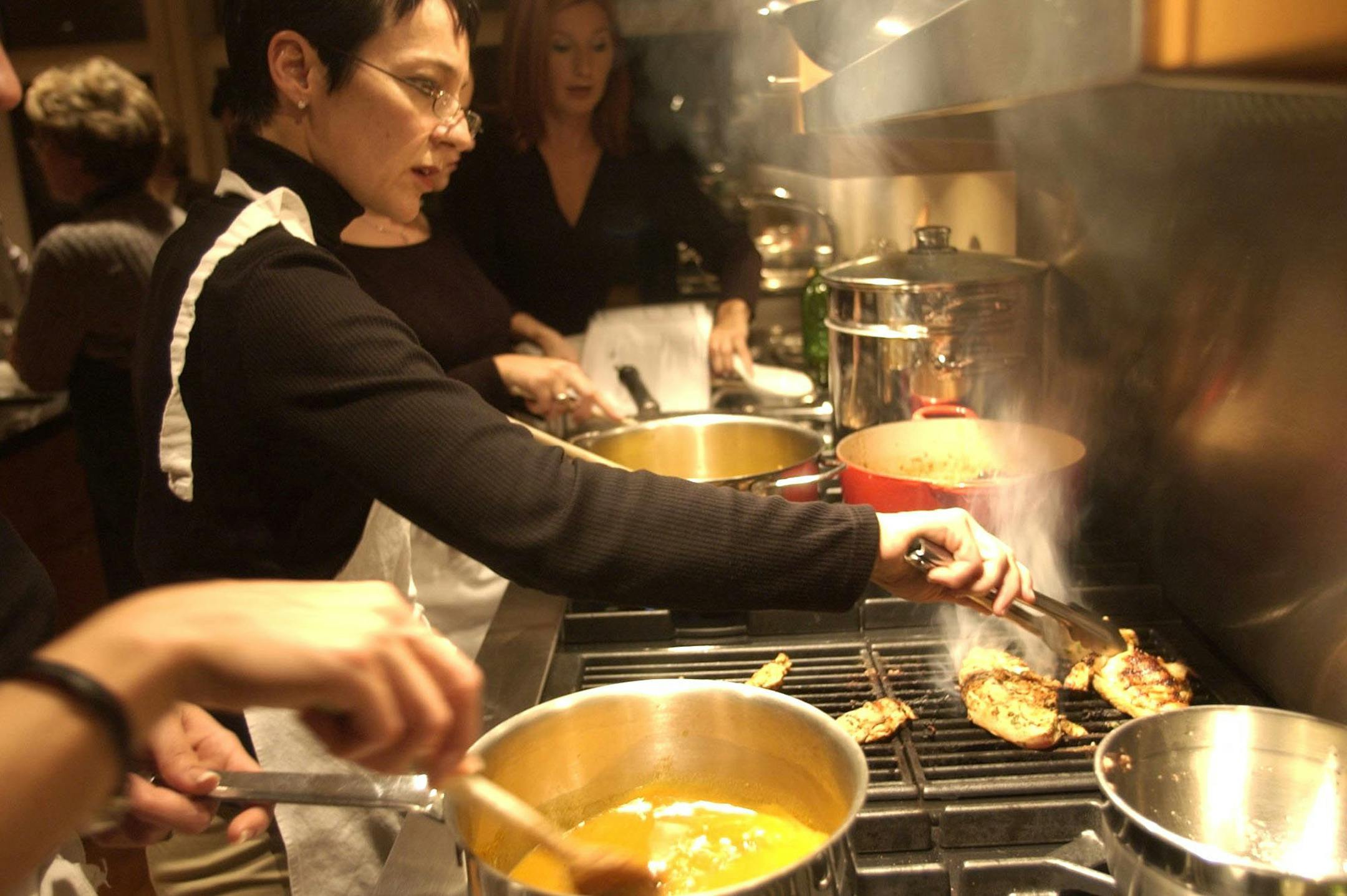 Student Lucie Asselin checks her food as she takes a pasta cooking class at the Cooking Studio in Windsor, Canada, in October 2003. (William Archie/Detroit Free Press/MCT) ORG XMIT: 1100369