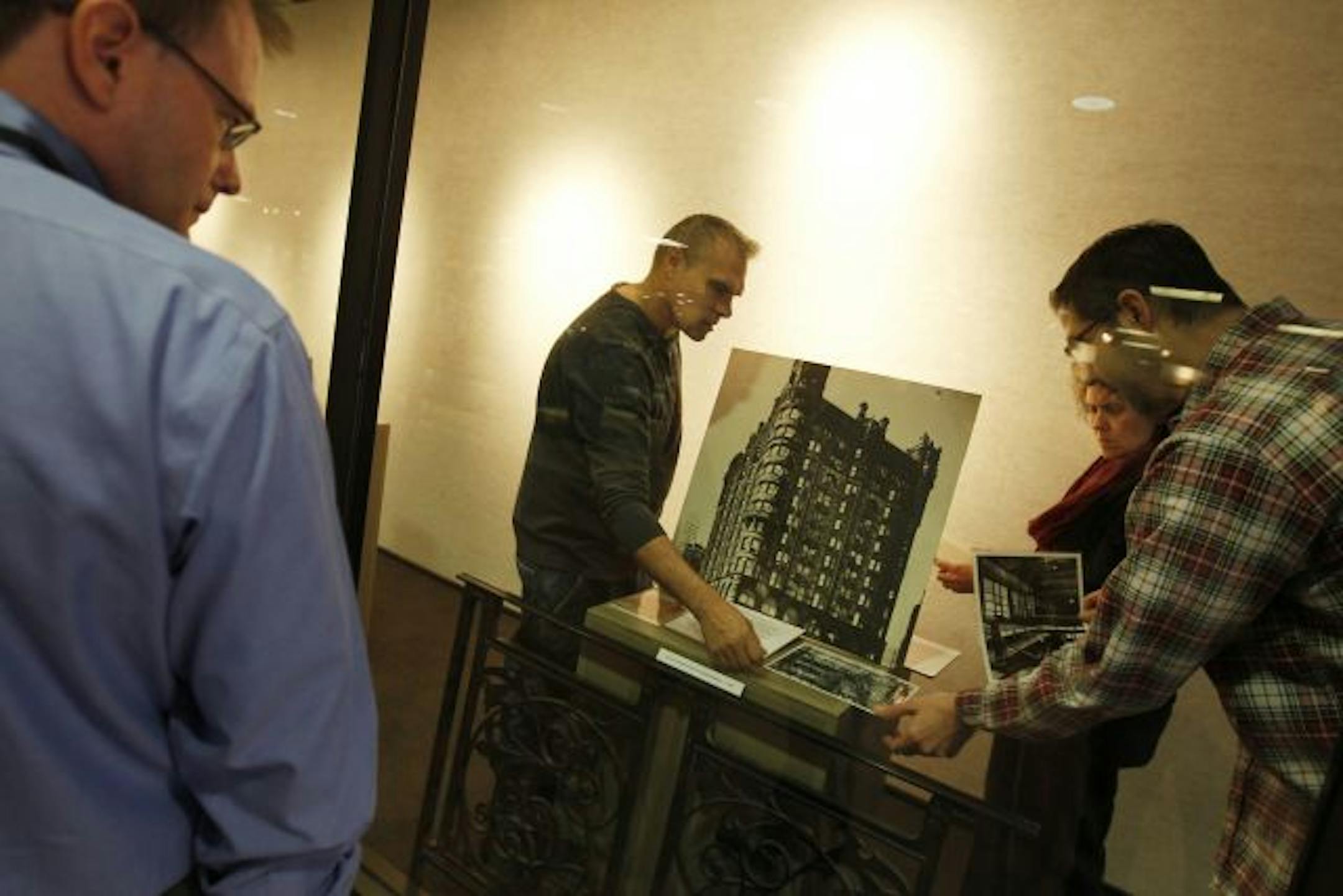 Matt Bower, a project coordinator for Minneapolis, checked out the exhibit on downtown architecture being prepared by curator Jack Karub, archivist Susan Larson-Fleming and volunteer Mick Patterson.