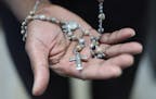Father Thomas Joseph of St. Nicholas Parish in Carver, Minn. holds the rosary Mother Teresa gave to him. Fr. Joseph has written a book about his time 