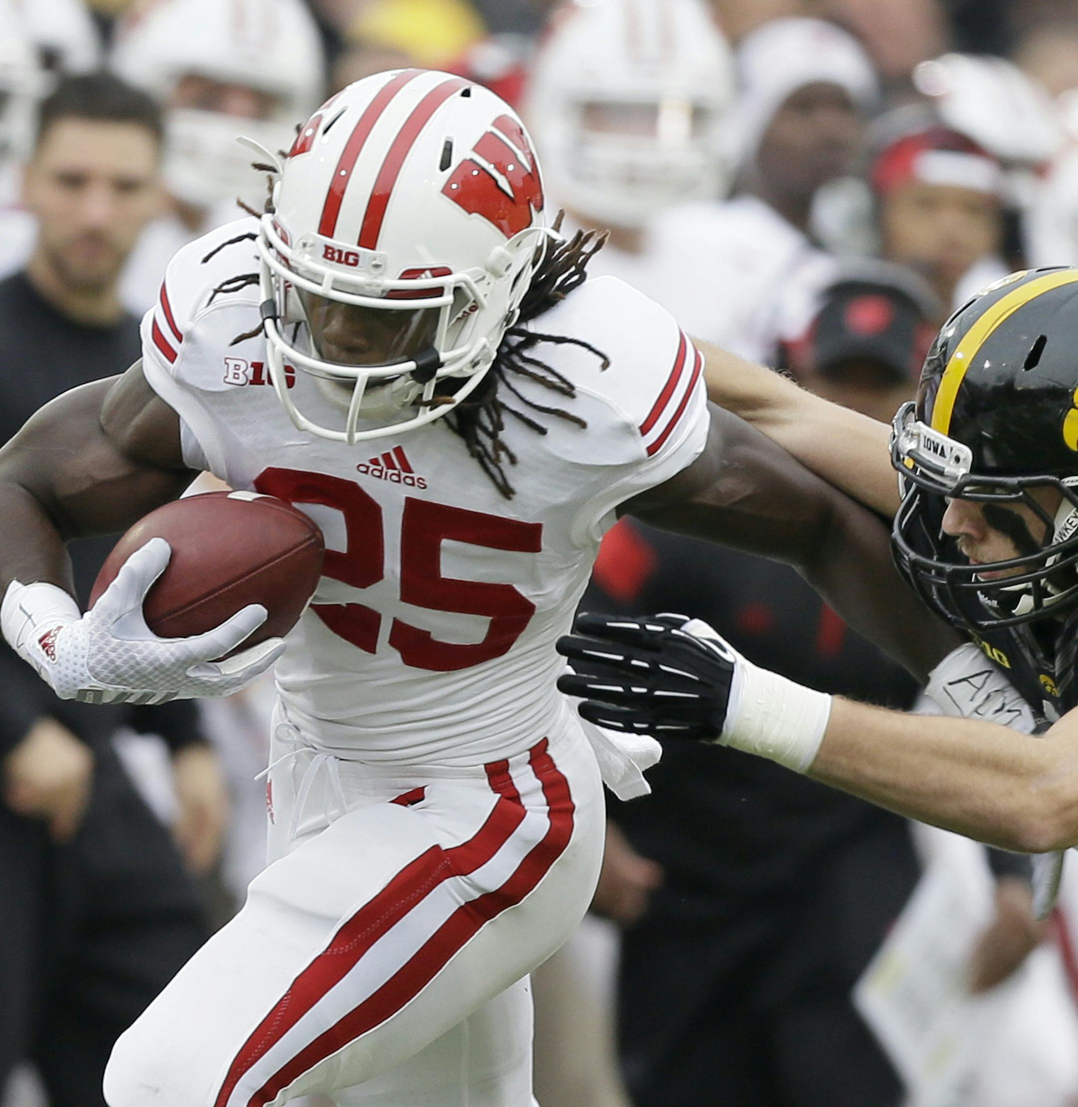 Wisconsin running back Melvin Gordon (25) runs from Iowa linebacker Bo Bower during the first half of an NCAA college football game, Saturday, Nov. 22, 2014, in Iowa City, Iowa. (AP Photo/Charlie Neibergall) ORG XMIT: MIN2014112720392332