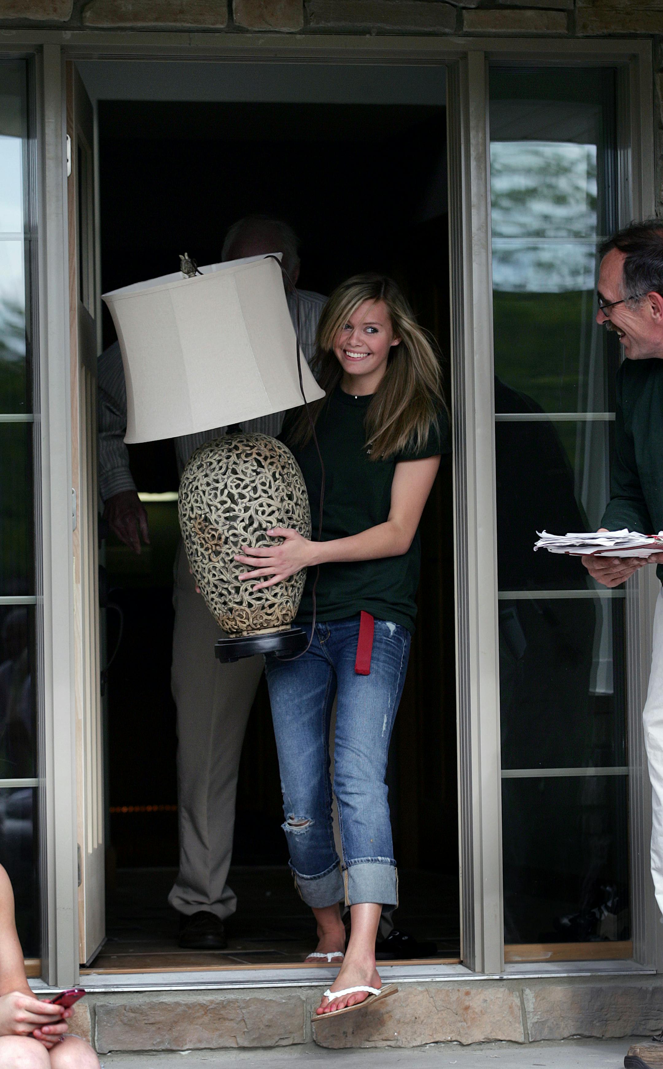 Spring Lake Park junior Elizabeth Asproth carried a lamp she won as a door prize from a new home at 8927 Pierce St. that she and her classmates in the Construction Trades Program built at 8927 Pierce St. At right is the program director Mark Voight.