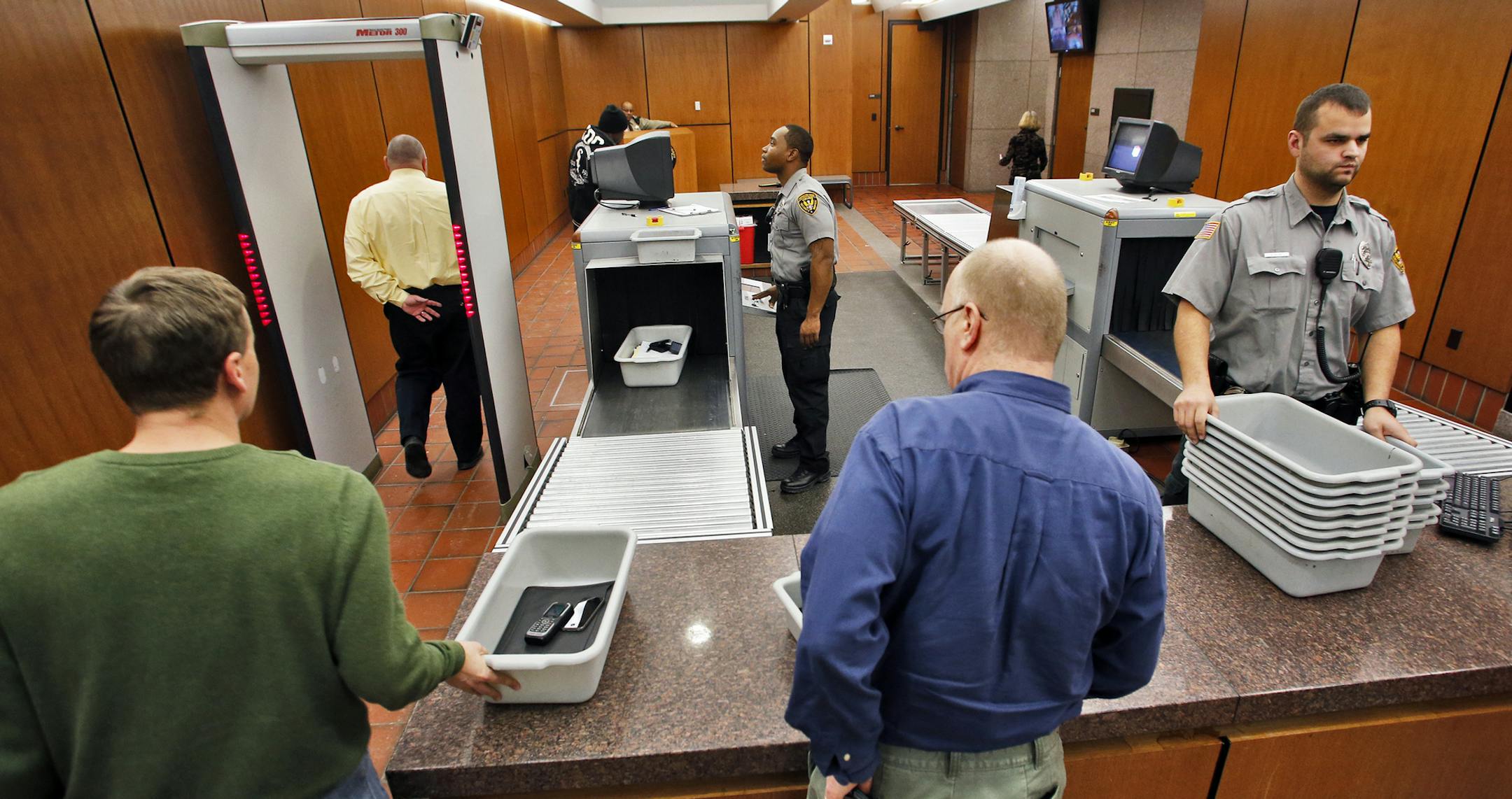 Courthouse screening is expanding in the metro area. A visual look at the screening area of the Hennepin County Government Center in Minneapolis. Viking Security agents Carlo Griggs, left, and Jon Kline checked people as they proceeded through the security machines. (MARLIN LEVISON/STARTRIBUNE(mlevison@startribune.com) ORG XMIT: MIN1312061527221829