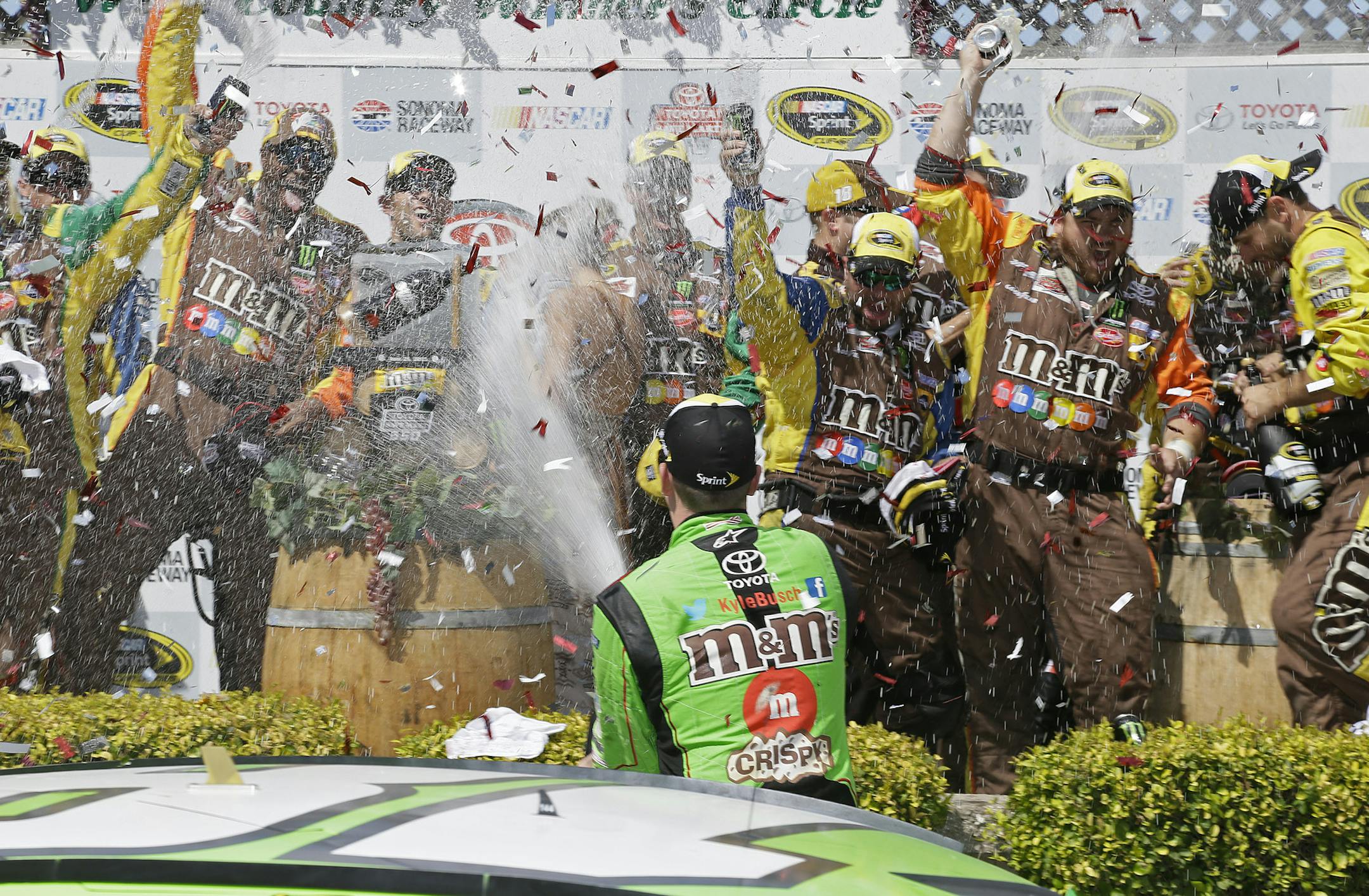 Kyle Busch sprays his crew after winning the NASCAR Sprint Cup Series auto race Sunday, June 28, 2015, in Sonoma, Calif. (AP Photo/Eric Risberg)