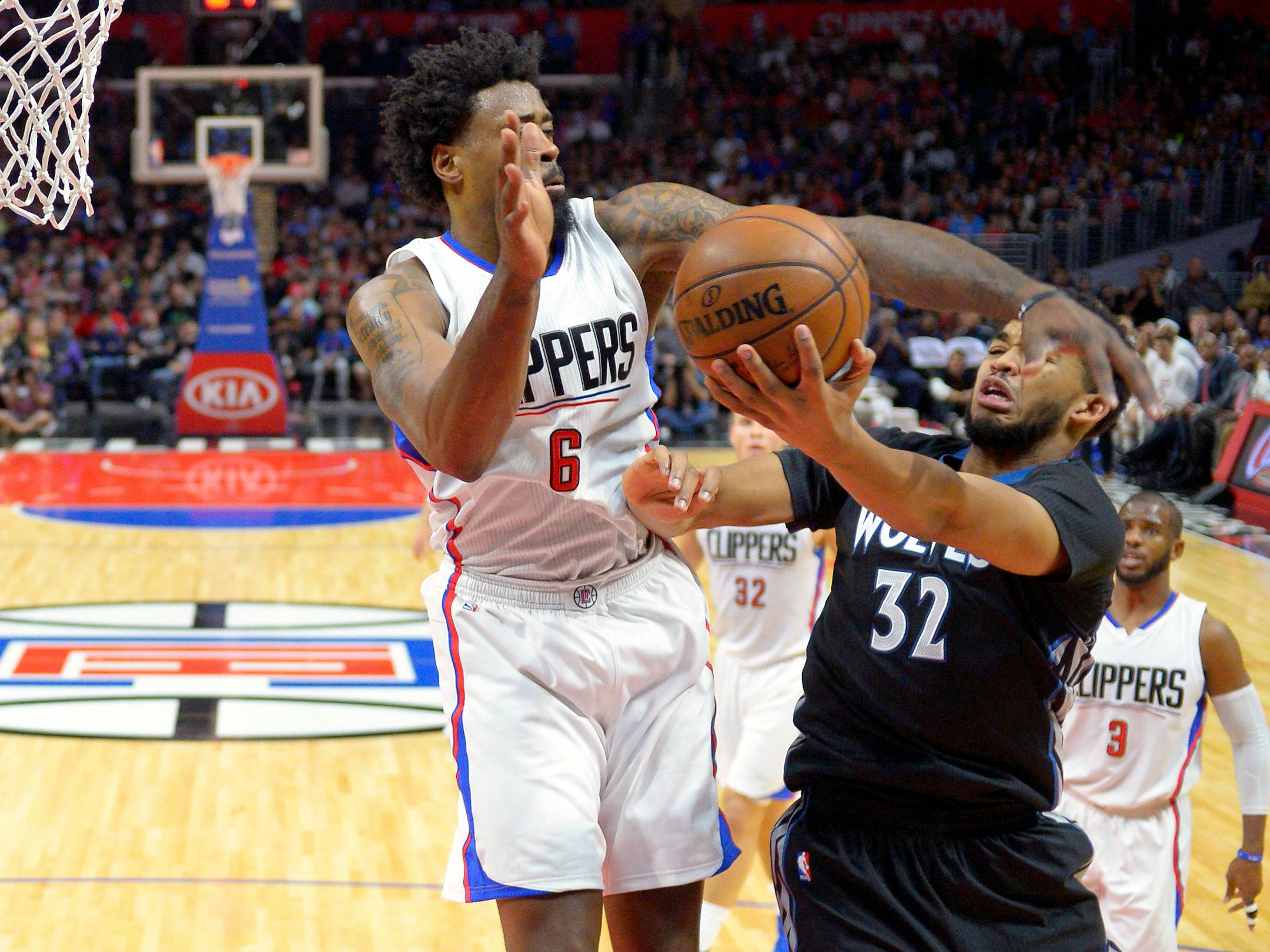 Minnesota Timberwolves center Karl-Anthony Towns, right, shoots as Los Angeles Clippers center DeAndre Jordan defends during the first half of an NBA basketball game, Sunday, Nov. 29, 2015, in Los Angeles. (AP Photo/Mark J. Terrill)