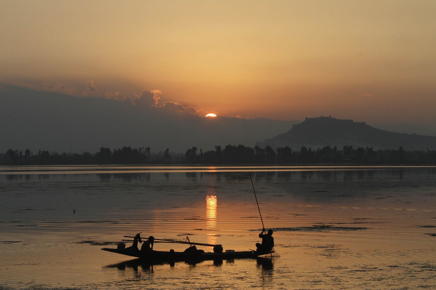 A Kashmiri fisherman fishes during sunset at the Dal Lake in Srinagar, the main city of India-held Kashmir, Sunday, Sept. 29, 2013. India and Pakistan, which have fought two wars over Kashmir, both claim the territory in its entirety while governing parts of it. (AP Photo/Mukhtar Khan)