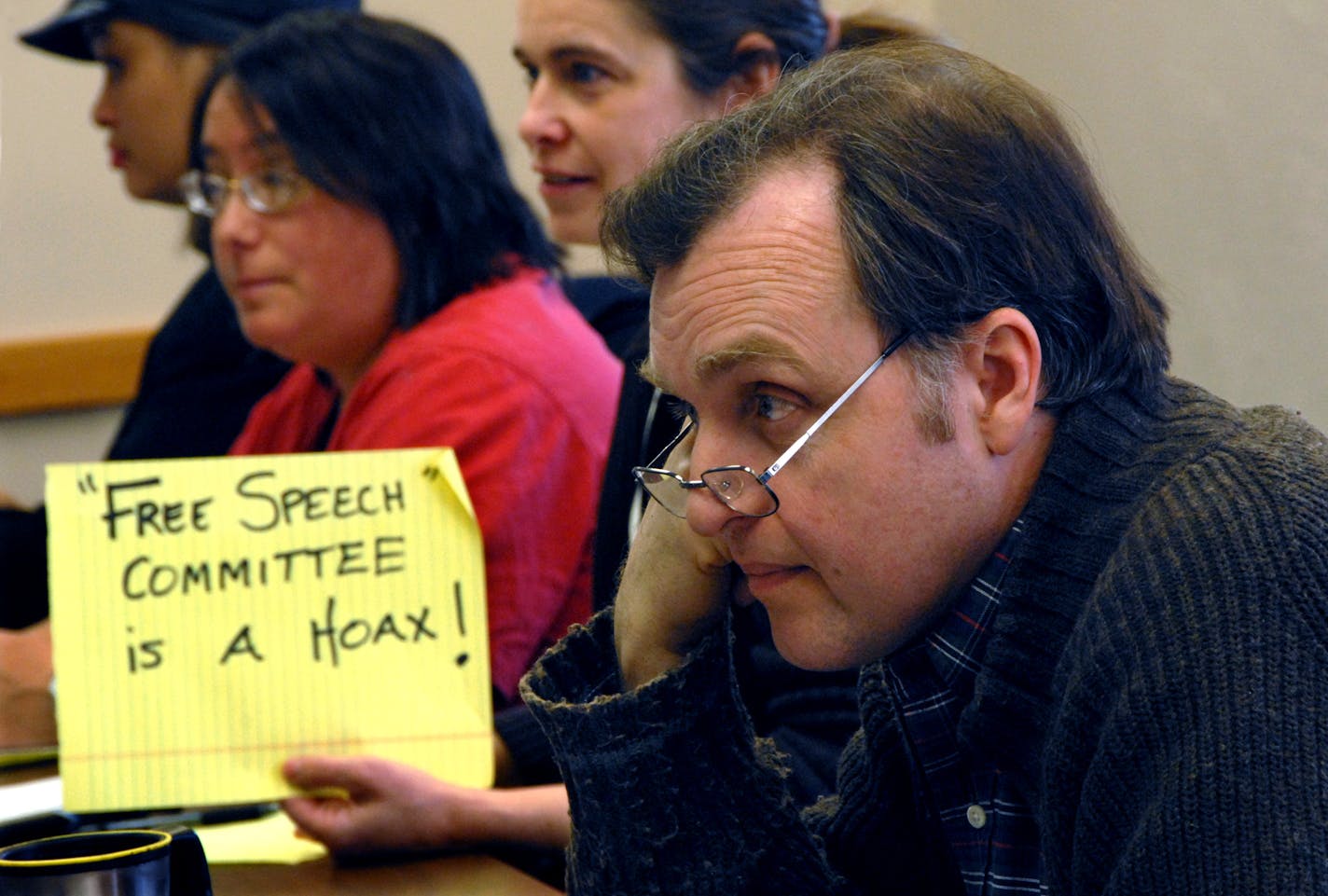 Minneapolis City Council Member Cam Gordon listened during the city government committee meeting considering a proposal on demonstration permits. Gordon opposes mandatory permits for demonstrations. Protesters sat in on the meeting and held signs to express their views because the meeting was not a public hearing.