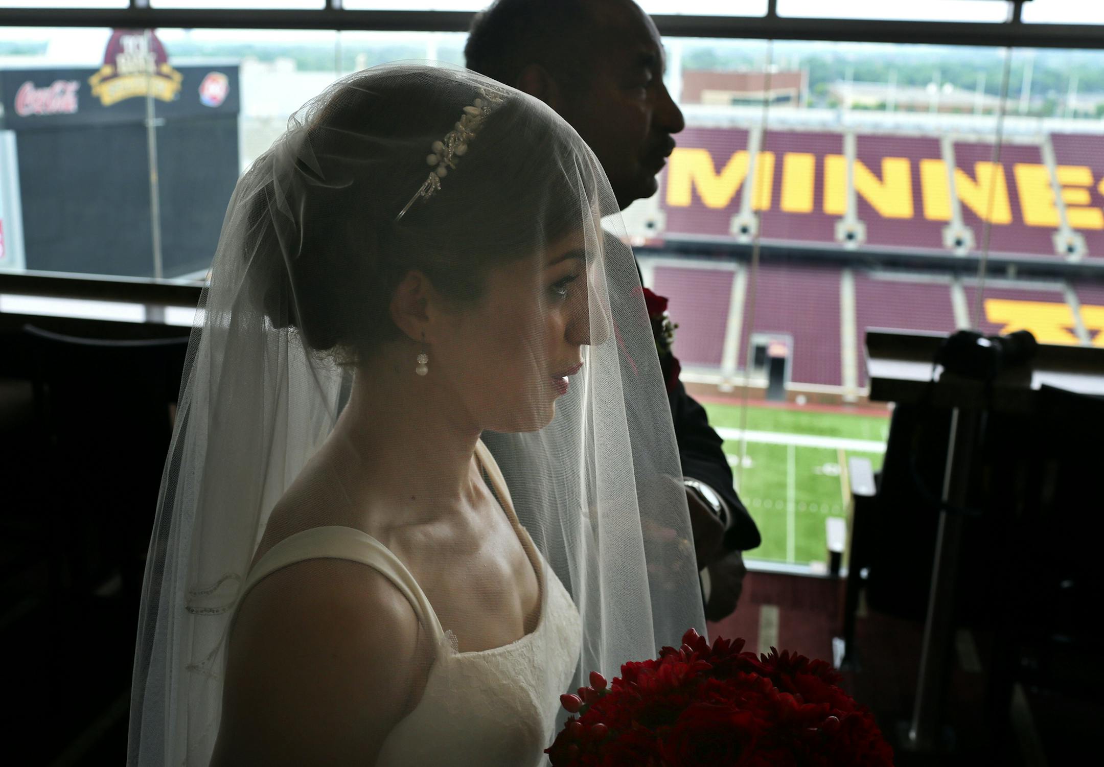With her father William Dean by her side, bride Samantha Dean exhaled before beginning the walk down the aisle for her wedding ceremony with groom Desmond Jones at the Indoor Club Room on the 6th floor of the TCF Bank Stadium.
